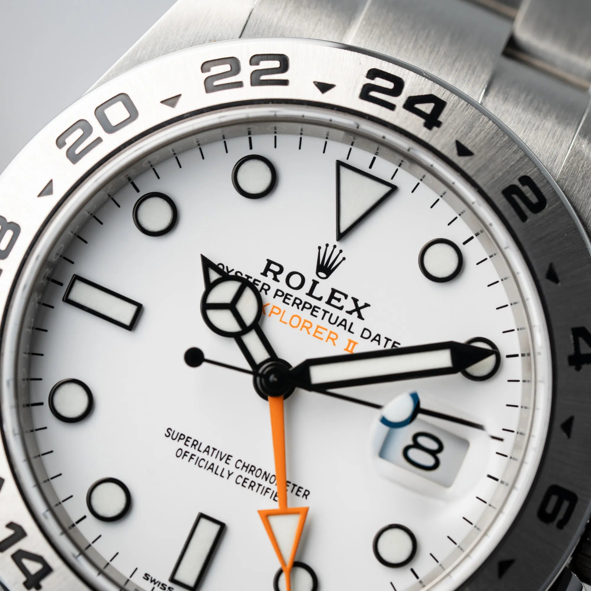 Makroaufnahme des Zifferblatts der Rolex Explorer II 216570 aus 2021 mit dem weißen Polar Zifferblatt mit dem typischen orangen GMT-Zeiger in einem sehr guten Zustand