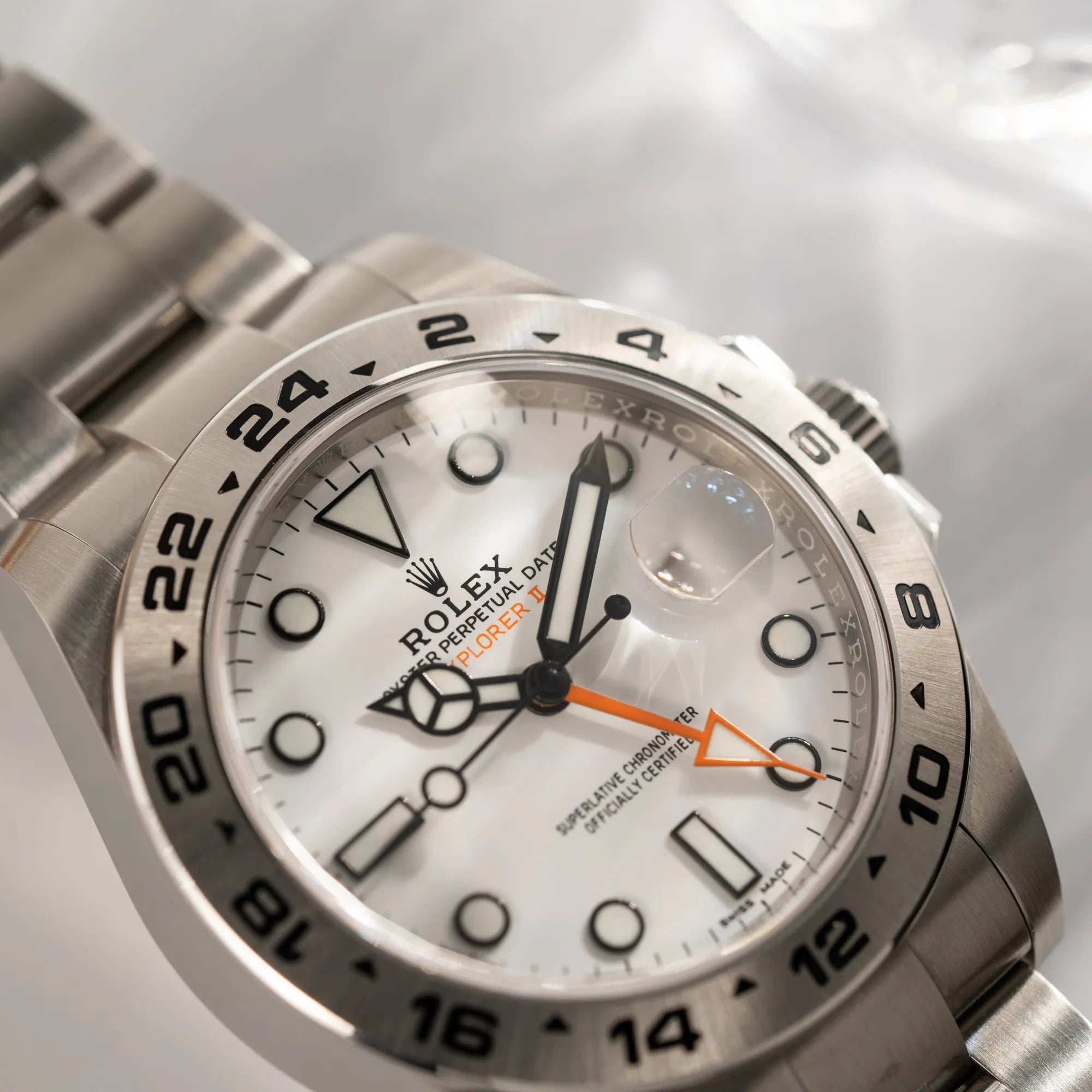 Detailaufnahme der Rolex Explorer II 216570 aus 2021 mit dem weißen Polar Zifferblatt mit dem typischen orangen GMT-Zeiger in einem sehr guten Zustand