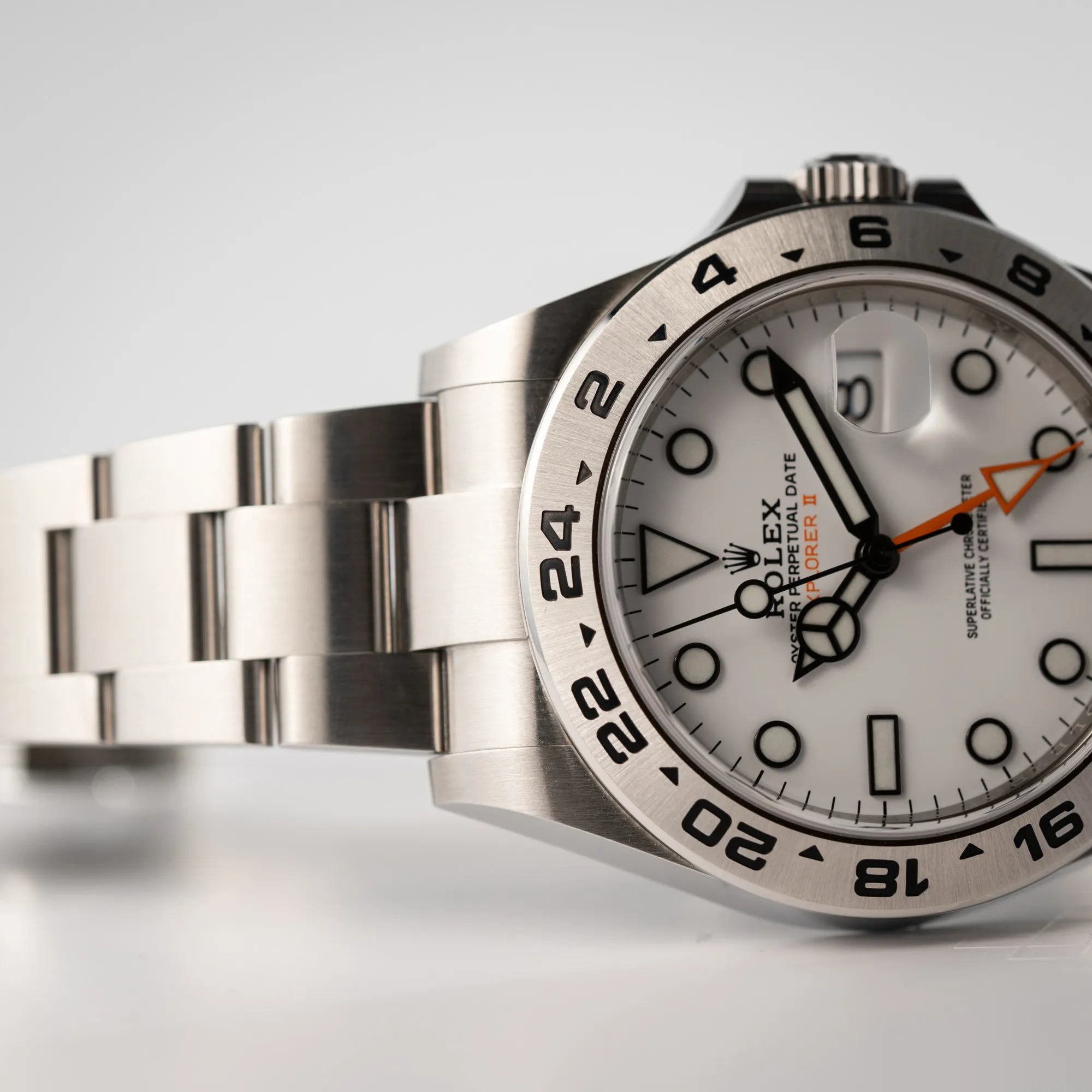 Produktfotografie der Rolex Explorer II 216570 aus 2021 mit dem weißen Polar Zifferblatt mit dem typischen orangen GMT-Zeiger in einem sehr guten Zustand mit Fokus auf dem oberen Bandanstoß