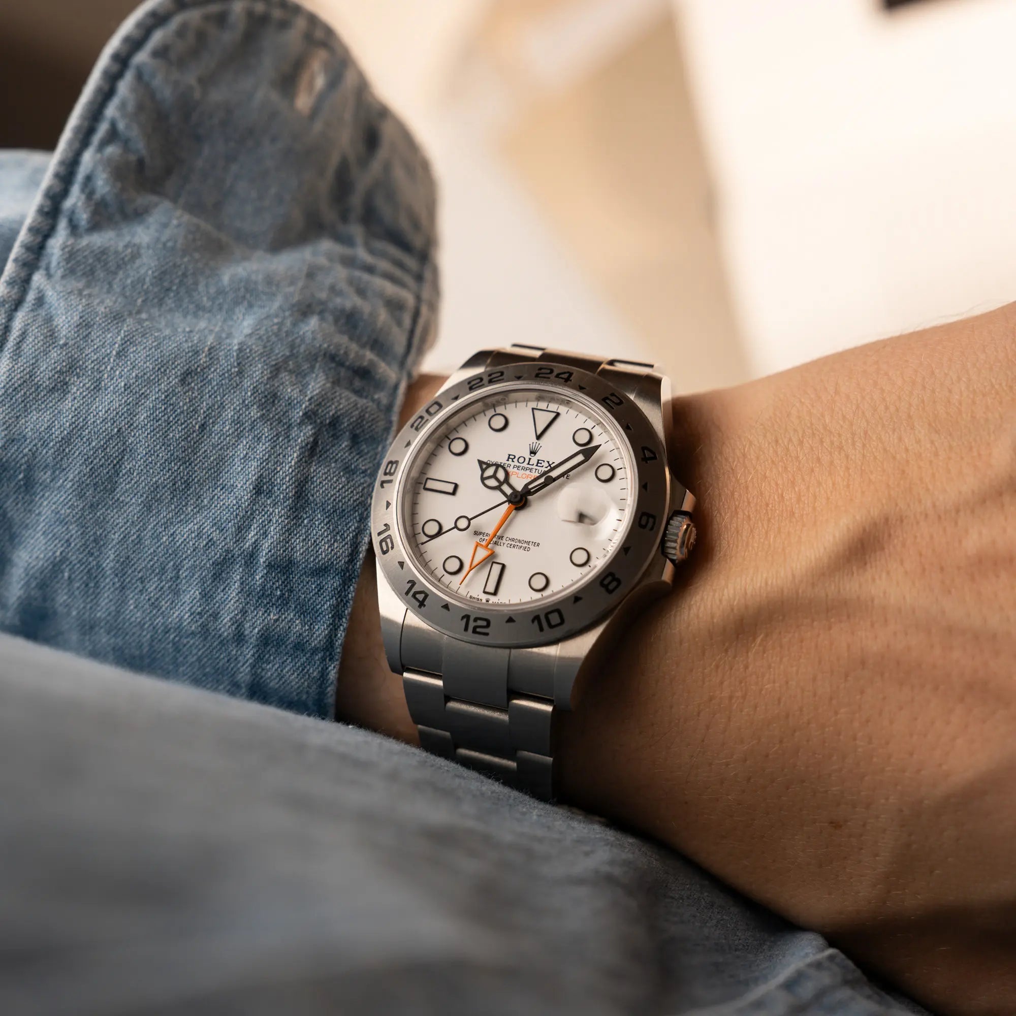 Mann trägt die Rolex Explorer 2 der Referenz 226570 mit dem Polar Zifferblatt und orangem GMT-Zeiger am Handgelenk für einen Wristshot