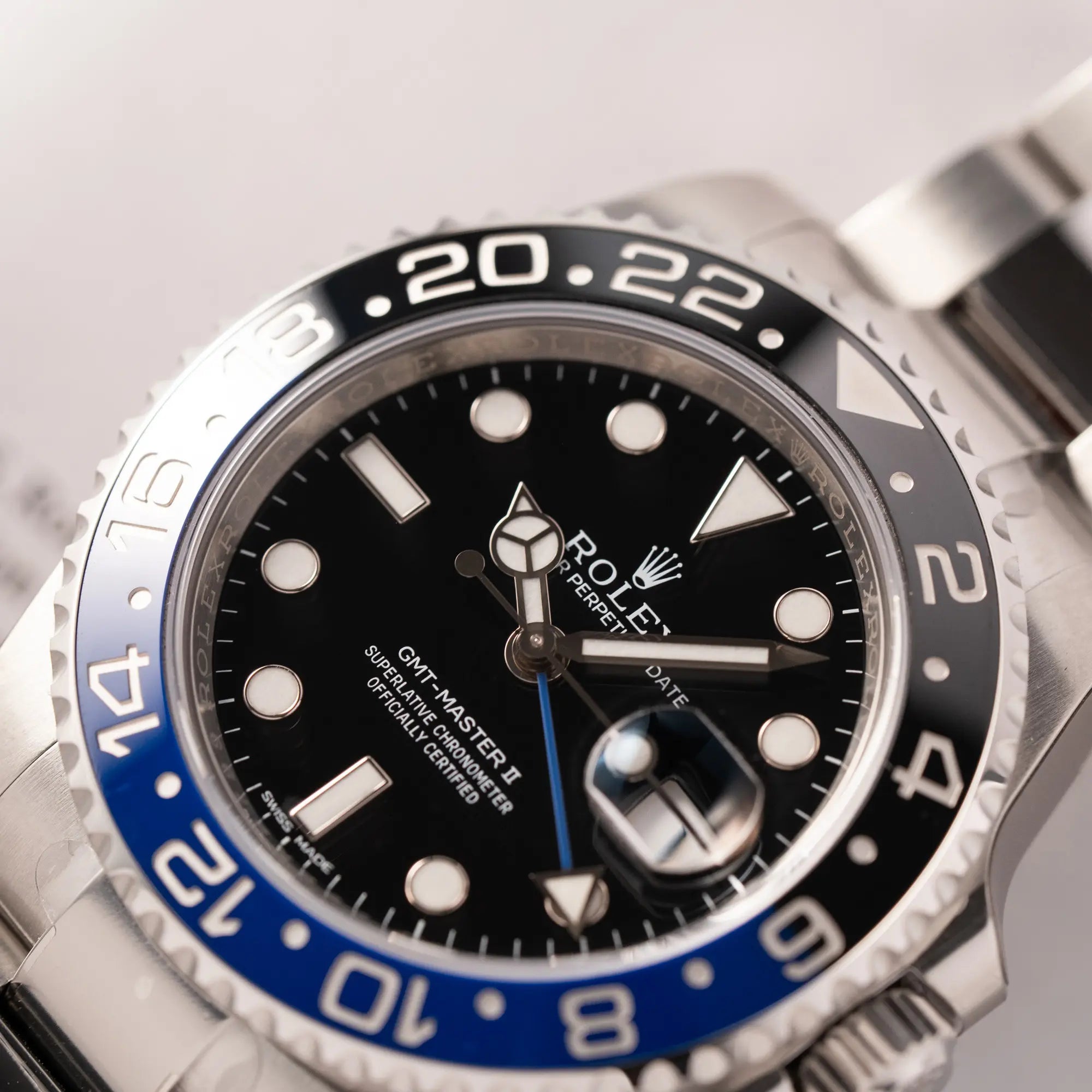 Detailaufnahme des Uhrenkopfes von der Rolex GMT-Master II der Referenz 116710BLNR mit dem Nickname "Batman" mit der schwarz blauen Keramik-Lünette am Oyster-Stahlband im verklebten Neuzustand