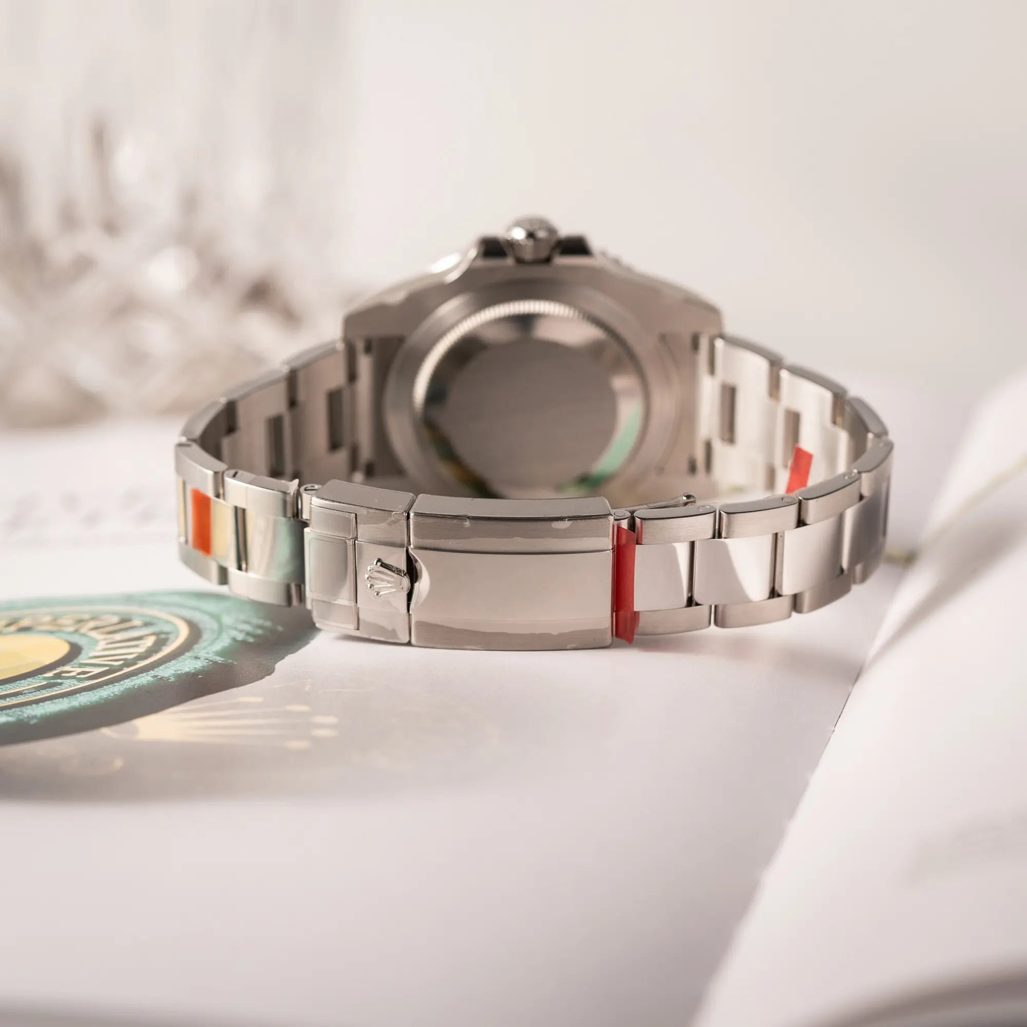 Produktfotografie zeigt die roten Sticker am Armband der Rolex GMT-Master II der Referenz 116710BLNR mit dem Nickname "Batman" mit der schwarz blauen Keramik-Lünette am Oyster-Stahlband im verklebten Neuzustand