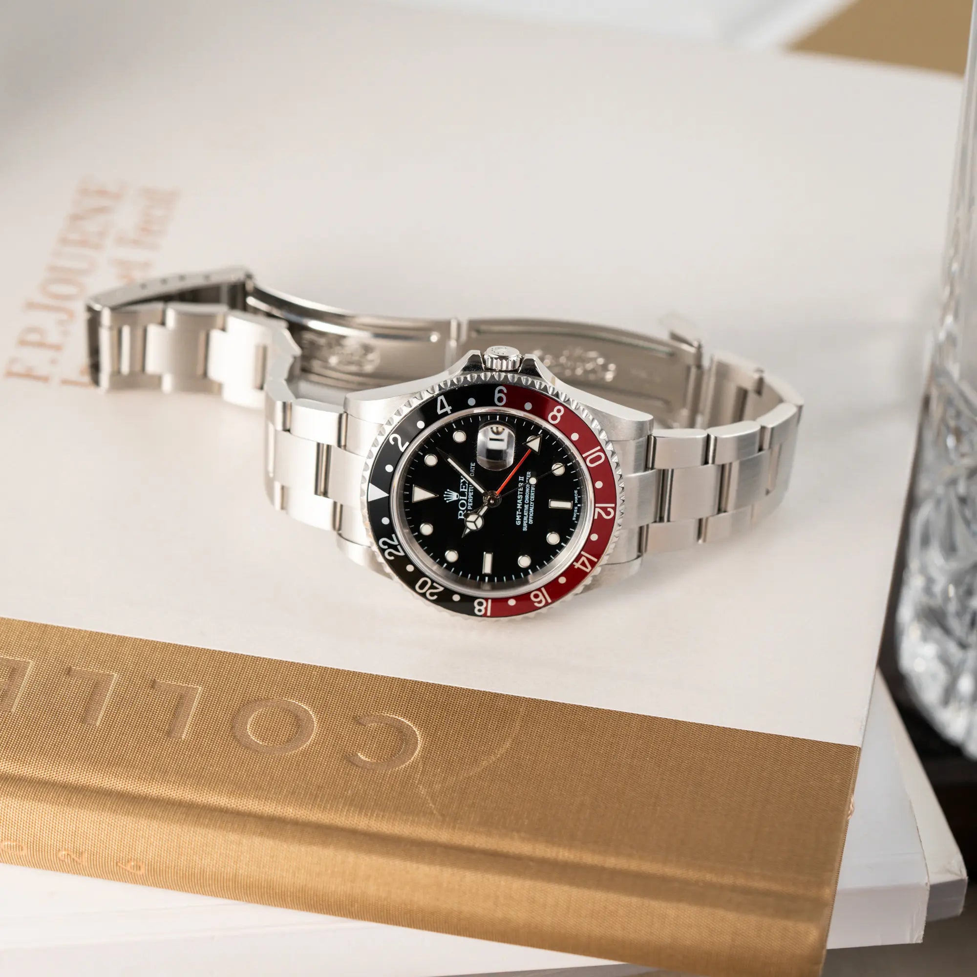 Fotografie der Rolex GMT-Master II 16710 mit der schwarz-roten "Coke" Aluminium-Lünetten-Einlage aus 2003 am Oyster Stahlband mit geöffneter Faltschliesse