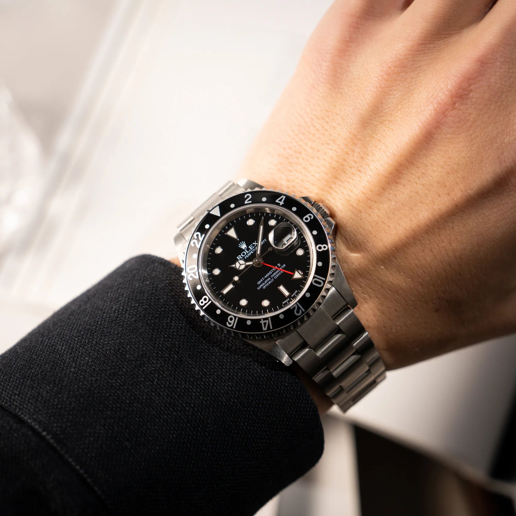 Mann trägt die Rolex GMT-Master II 16710  aus 2001 mit schwarzem Aluminium-Lünetten-Inlay in einem neuwertigen Zustand an seinem handgelenk