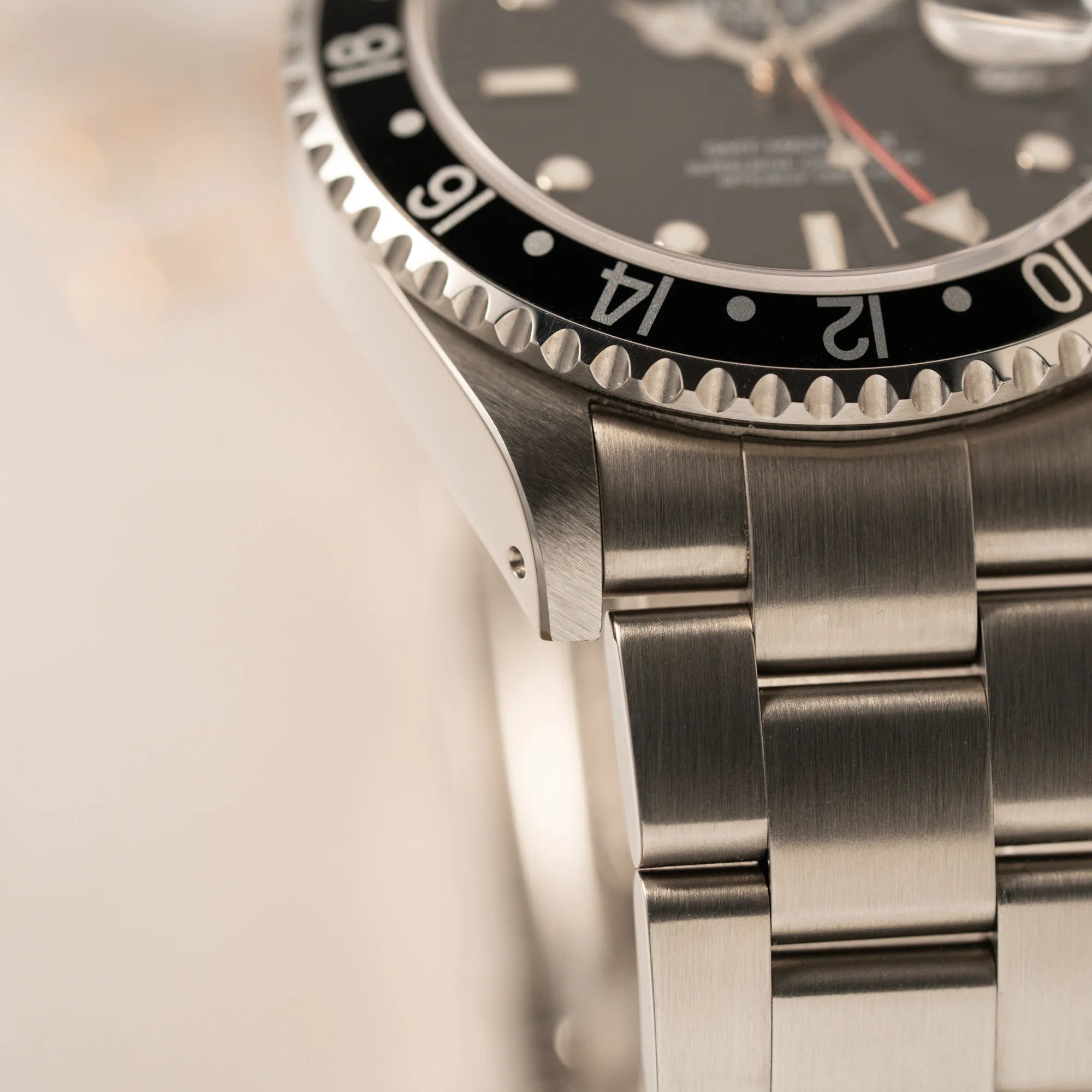 Detailaufnahme des unteren linken Bandanstoßes der Rolex GMT-Master II 16710  aus 2001 mit schwarzem Aluminium-Lünetten-Inlay in einem neuwertigen Zustand