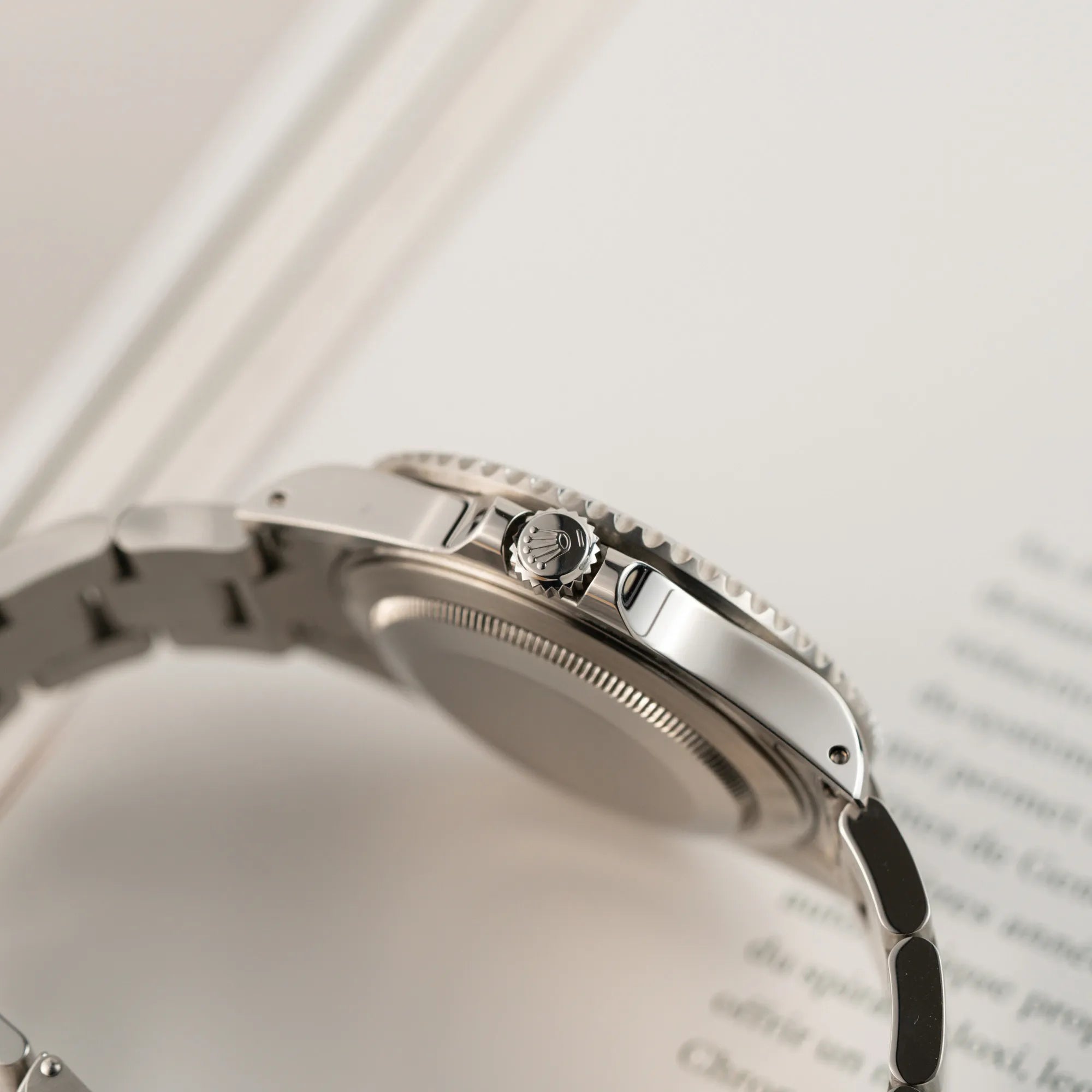 Produktfotografie zeigt die Aufzugskrone der Rolex GMT-Master II 16710  aus 2001 mit schwarzem Aluminium-Lünetten-Inlay in einem neuwertigen Zustand