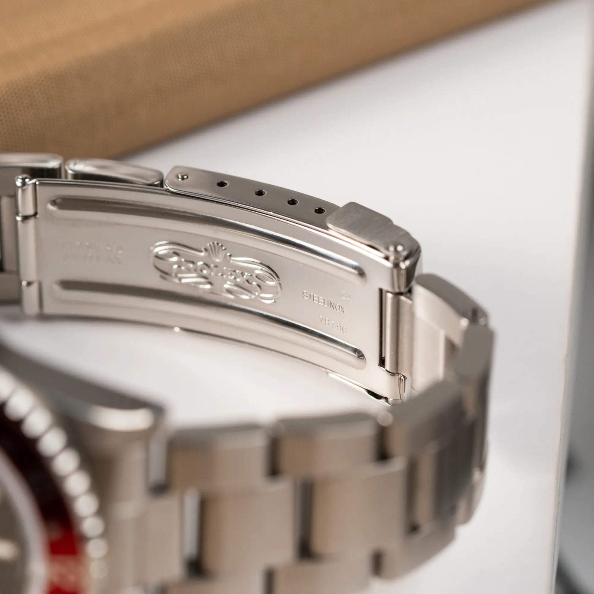 Produktfotografie zeigt das klassiche Rolex Logo im Inneren der Oyster-Faltschliesse der Rolex GMT Master 2 der Referenz 16710 aus der T-Serie mit blau-roter Pepsi-Lünette