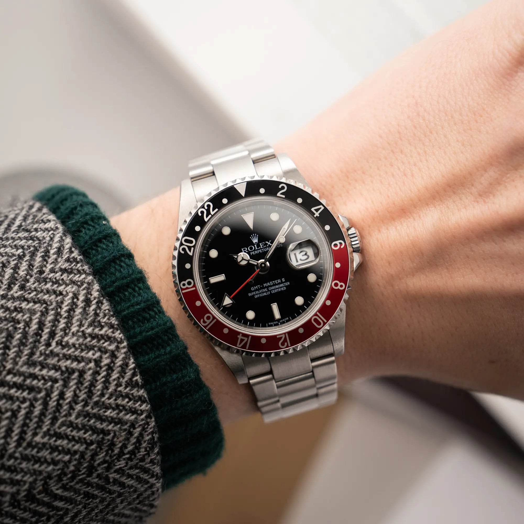 Mann trägt die Rolex GMT-Master II der Referenz 16710 mit der schwarz-roten "Coke"-Lünette aus 2007 mit dem "No-Hole"-Uhrengehäuse an seinem Handgelenk