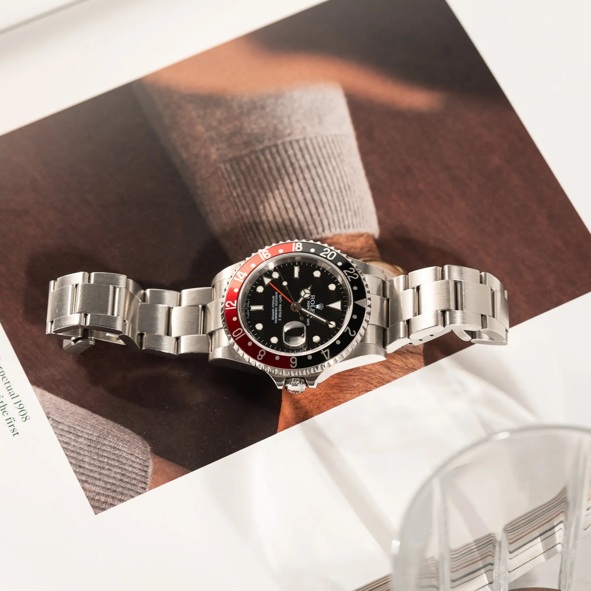 Rolex GMT-Master II der Referenz 16710 mit der schwarz-roten "Coke"-Lünette aus 2007 mit dem "No-Hole"-Uhrengehäuse liegt auf Uhrenmagazin