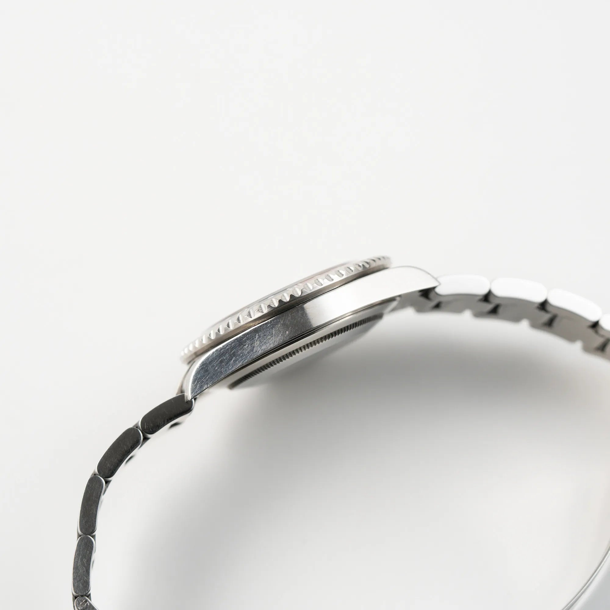 Seitliche Gehäuseflanke der Rolex GMT-Master II der Referenz 16710 mit der schwarz-roten "Coke"-Lünette aus 2007 mit dem "No-Hole"-Uhrengehäuse