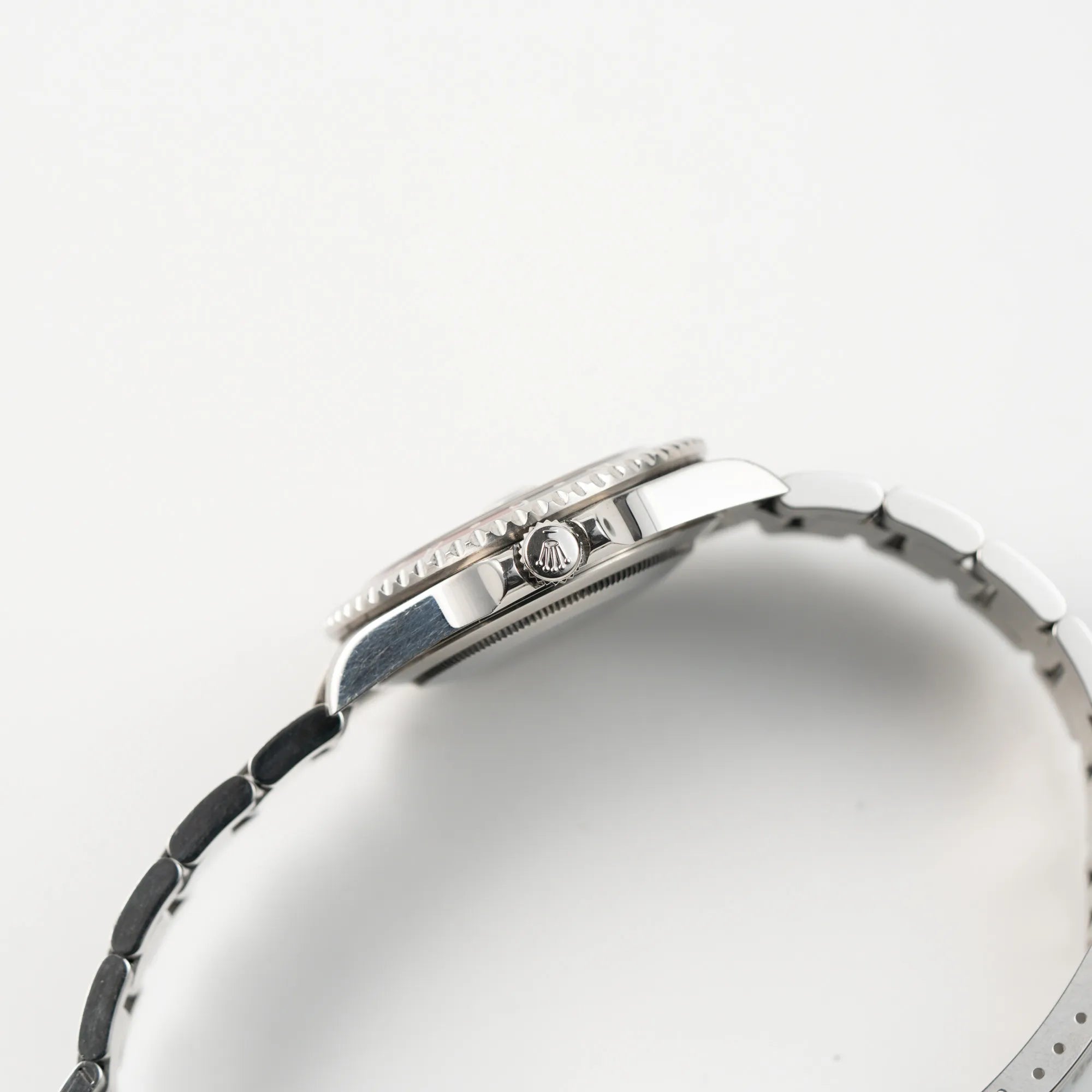 Seitliche Gehäuseflanke der Rolex GMT-Master II der Referenz 16710 mit der schwarz-roten "Coke"-Lünette aus 2007 mit dem "No-Hole"-Uhrengehäuse mit Blick auf die Aufzugskrone