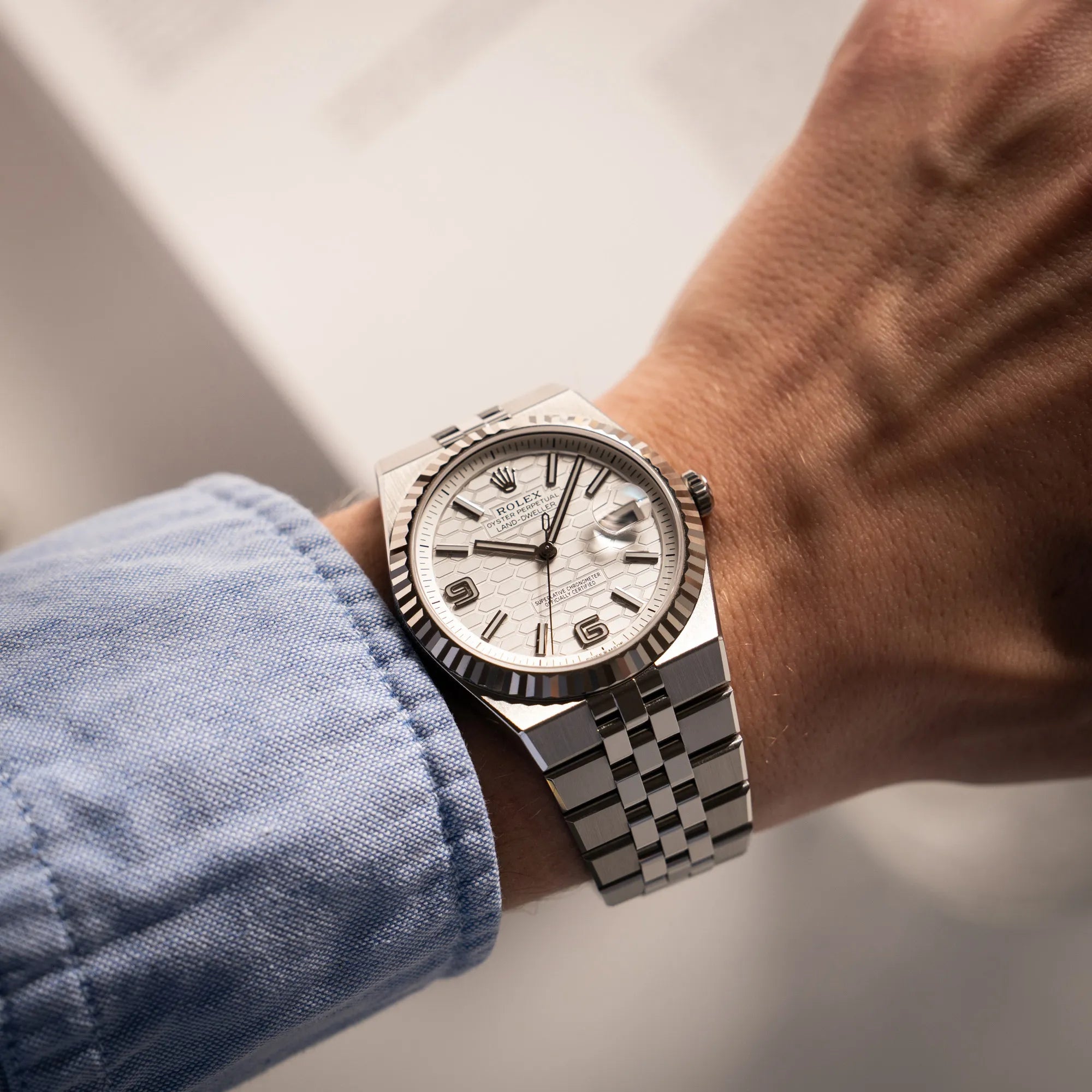 Mann trägt die Rolex Land-Dweller 40 der Referenz 127334 im neuwertigen Zustand mit dem weißen Zifferblatt in Waben-Struktur am neuen Flat-Jubilee-Armband