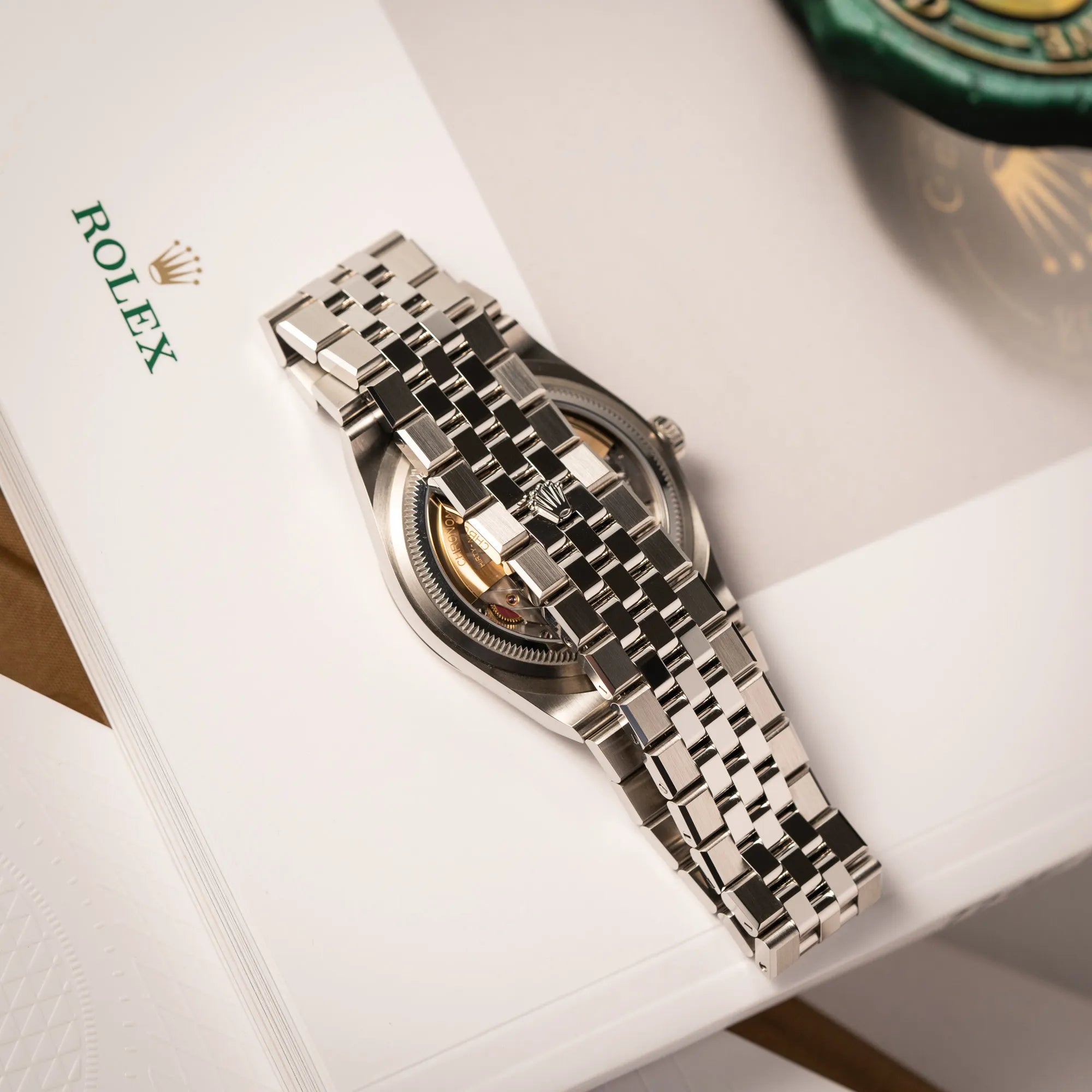 Prosuktfotografie der Rolex Land-Dweller 40 der Referenz 127334 im neuwertigen Zustand mit dem weißen Zifferblatt in Waben-Struktur zeigt das speziell für die Uhr entwickelte Flat-Jubilee-Armband