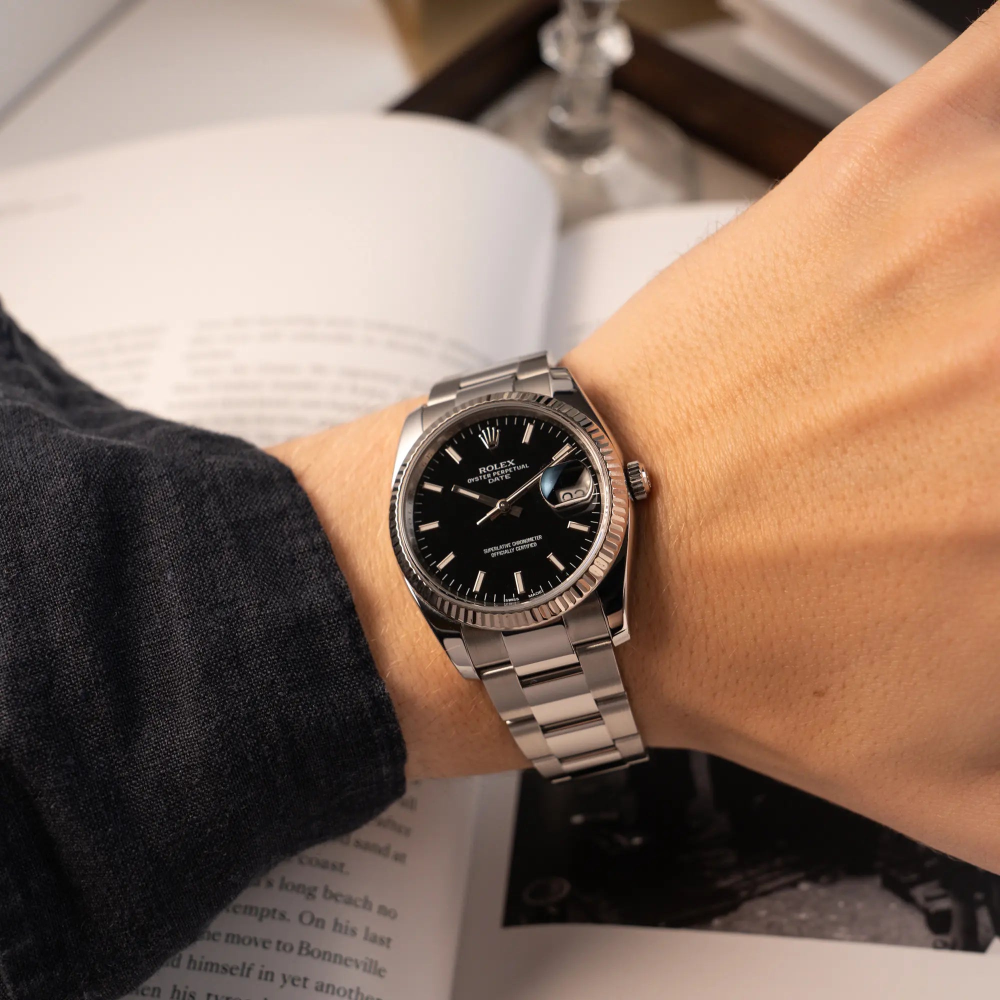 Wristshot mit der Rolex Oyster Perpetual Date 34 der Referenz 115234 mit schwarzem Zifferblatt und der geriffelten Weißgold-Lünette 