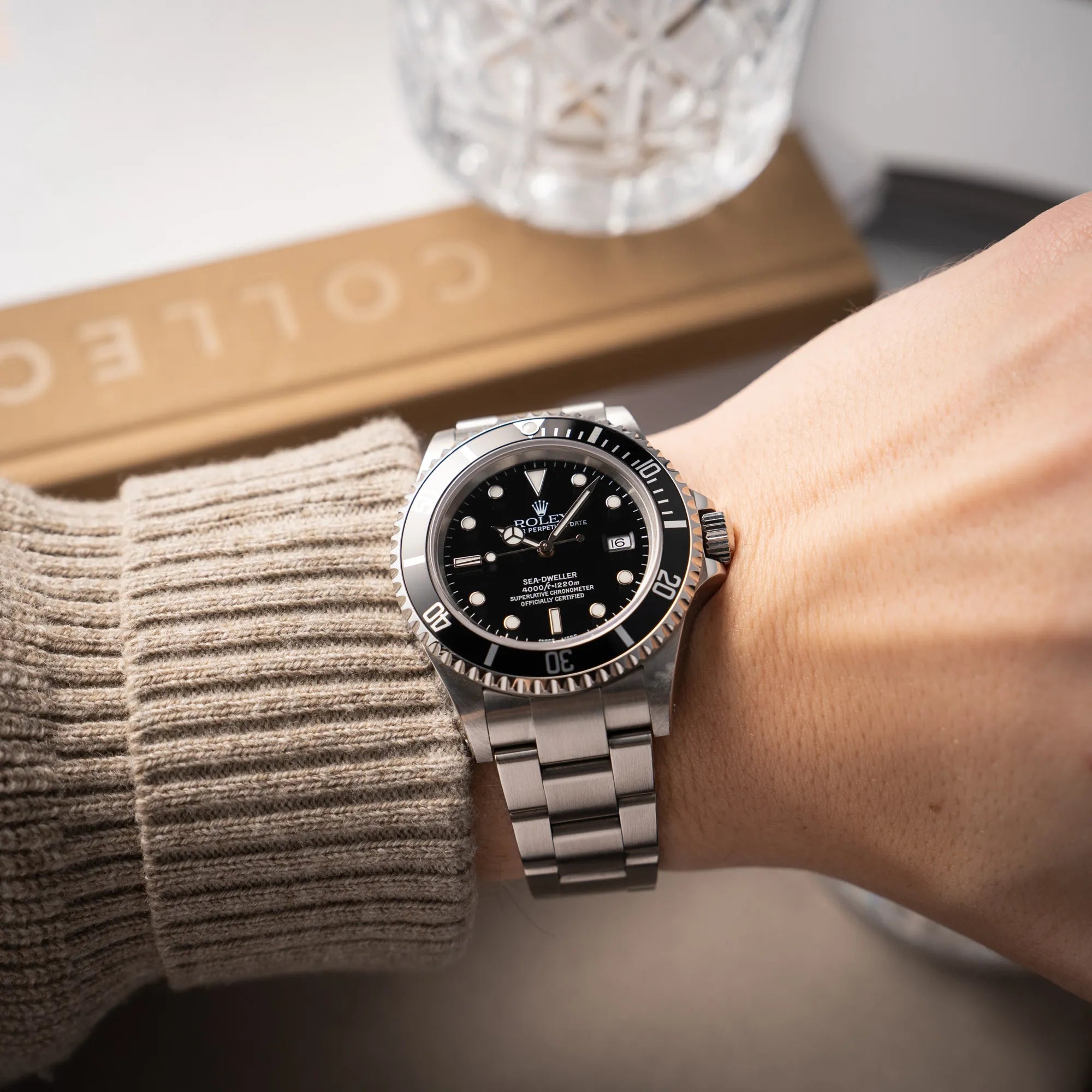 Mann trägt die Rolex Sea-Dweller  mit schwarzem Zifferblatt und schwarzer Aluminium-Lünetten-Einlage der Referenz 16600 aus 2000 für einen Wristshot an seinem Handgelenk