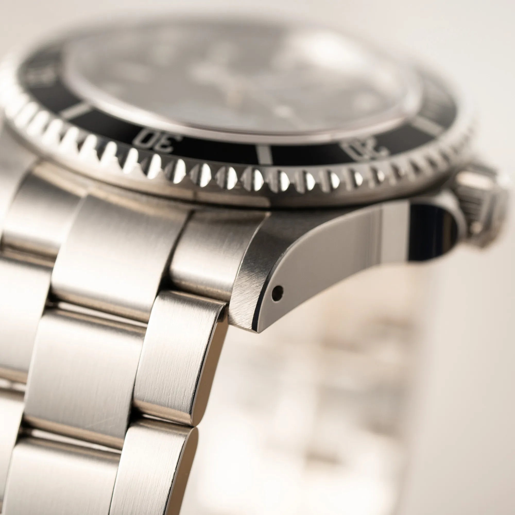 Detailaufnahme der Rolex Sea-Dweller  mit schwarzem Zifferblatt und schwarzer Aluminium-Lünetten-Einlage der Referenz 16600 aus 2000 zeigt den sehr guten Zustand mit originalen Phasen des Bandanstosses