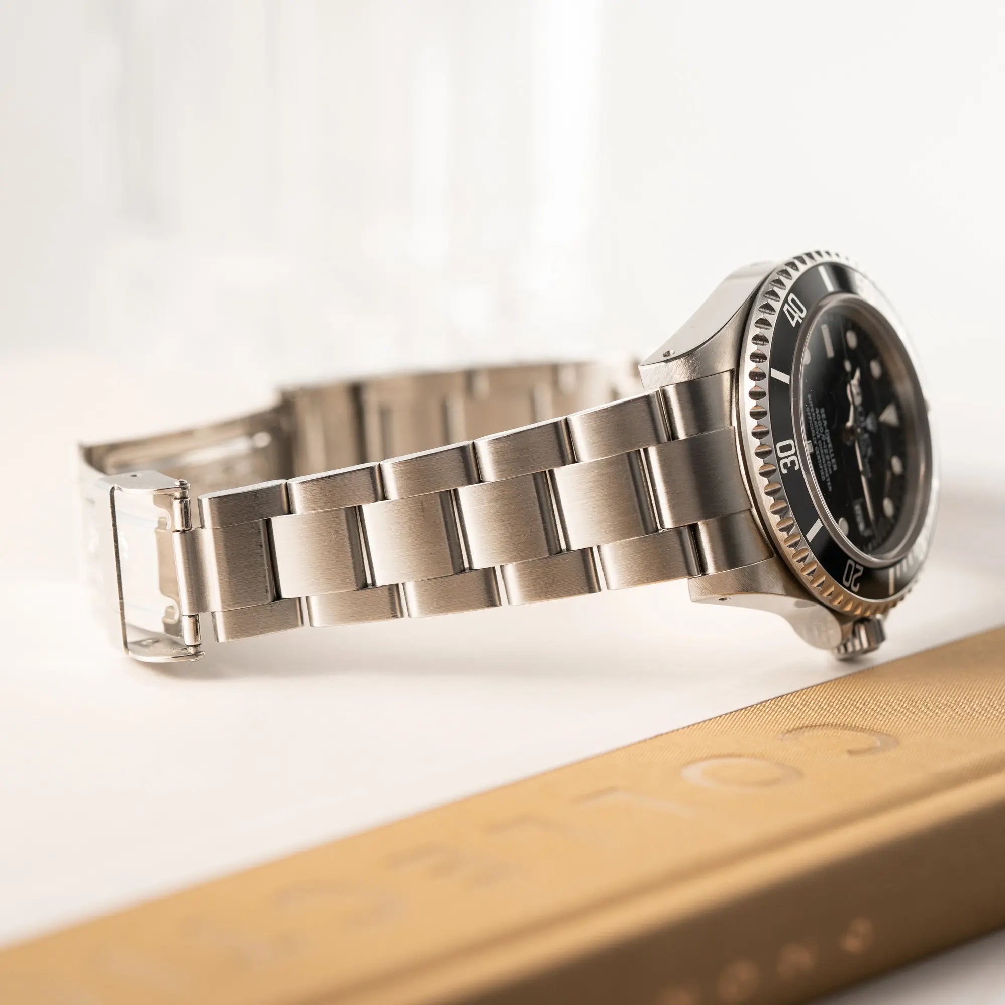 Produktfotografie der Rolex Sea-Dweller  mit schwarzem Zifferblatt und schwarzer Aluminium-Lünetten-Einlage der Referenz 16600 aus 2000 zeigt das Oyster-Stahlband in einem sehr guten Zustand mit sehr guter berflächenstruktur