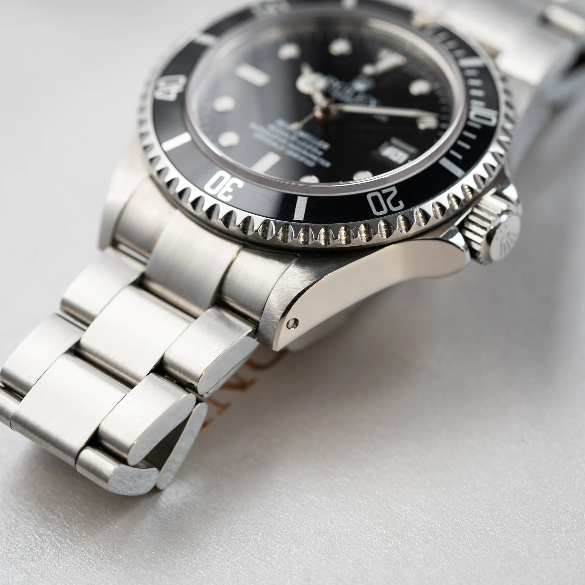 Produktfotografie der Rolex Sea-Dweller 4000 der Referenz 16600 mit der klassischen schwarzen Aluminium-Lünette aus Dezember 2002 mit Fokus auf dem Bandanstoß