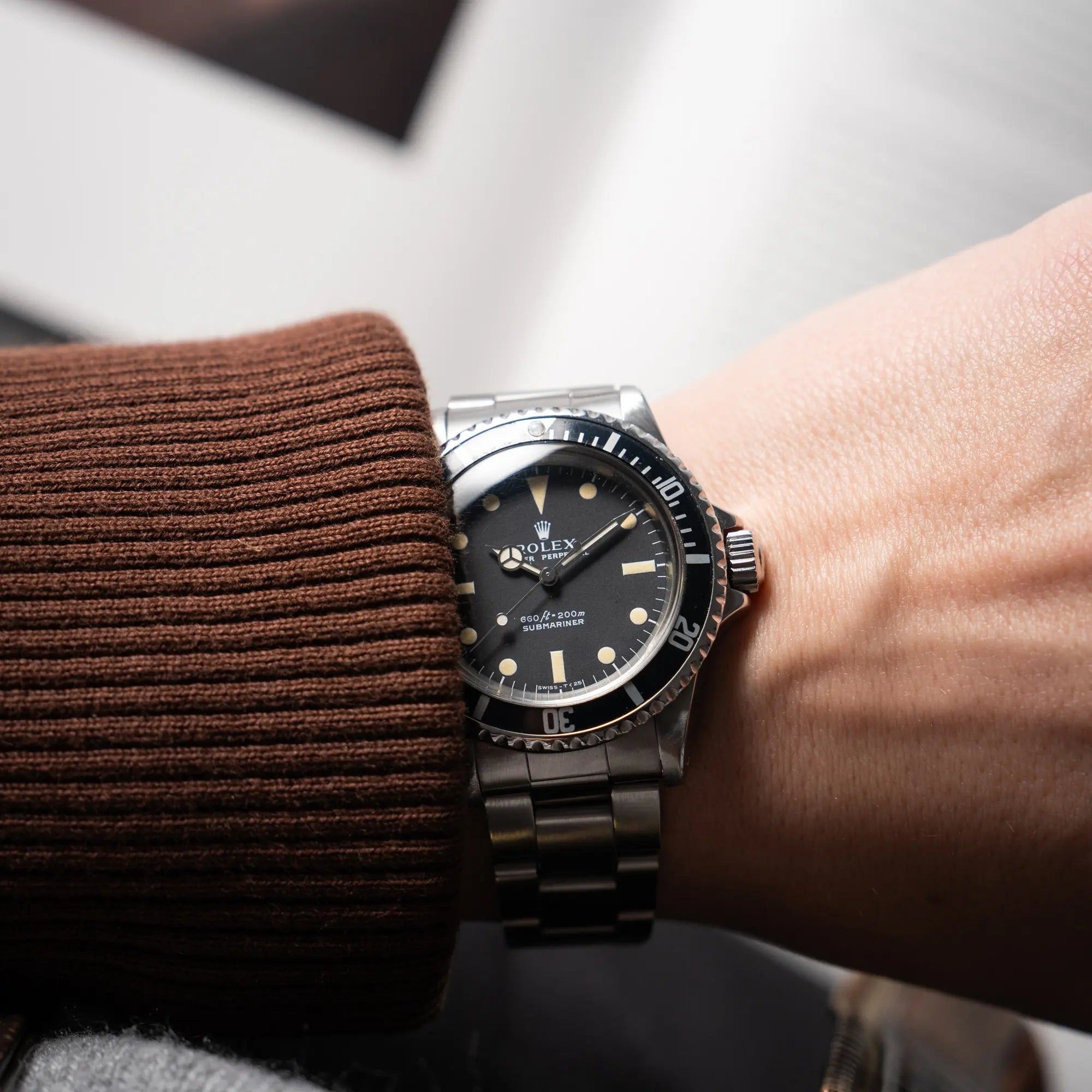 Mann trägt die Rolex Submariner No Date MKII mit Serif Zifferblatt der Referenz 5513 aus 1970 mit gleichmäßiger Patina an seinem Handgelenk