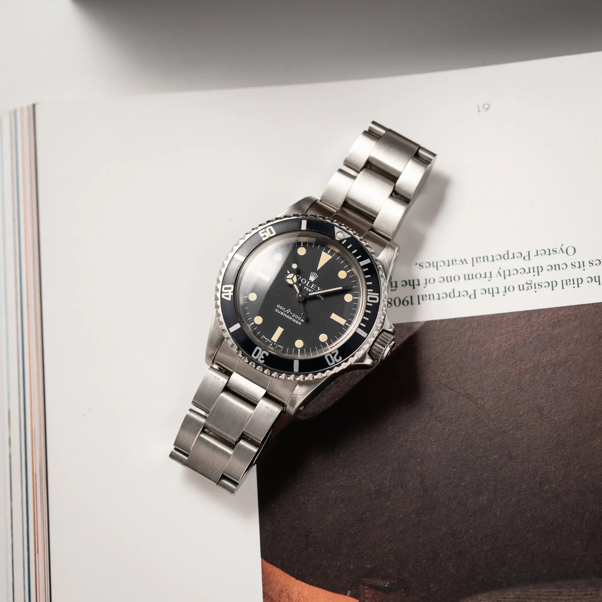 Rolex Submariner No Date MKII mit Serif Zifferblatt der Referenz 5513 aus 1970 mit gleichmäßiger Patina liegt auf einem Uhrenmagazin
