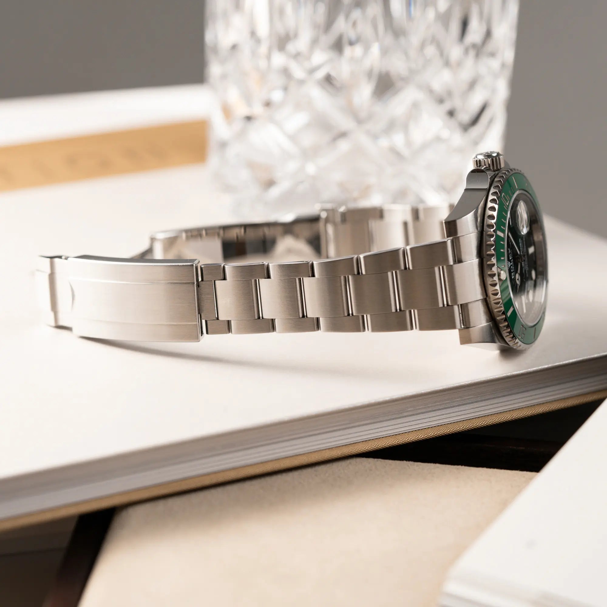 Produktfotografie der Rolex Submariner Date 116610LV "Hulk" mit grünem Zifferblatt und grüner Keramik-Lünette zeigt das Oyster-Stahland in einem sehr guten Zustand