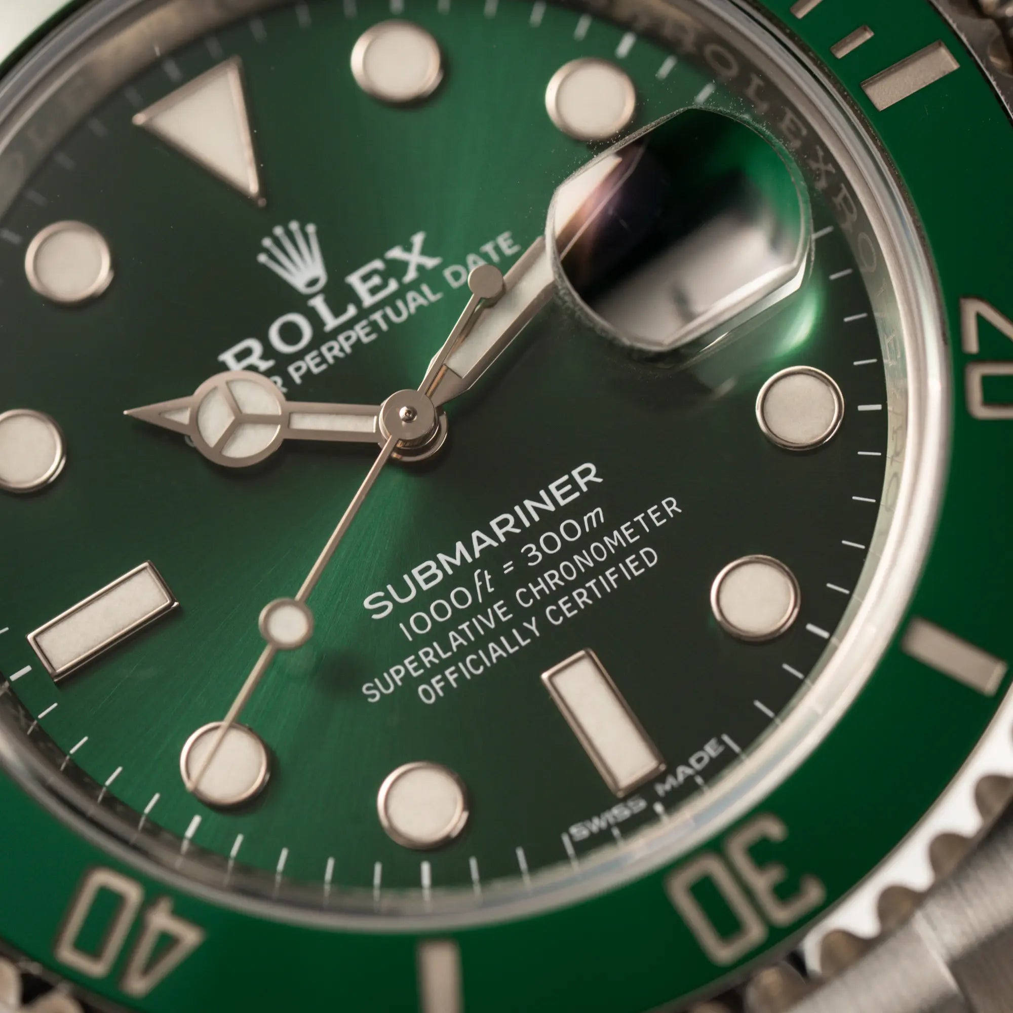 Makroaufnahme der Rolex Submariner Date 116610LV "Hulk" mit grünem Zifferblatt und grüner Keramik-Lünette mit Fokus auf dem Submariner-Schriftzug