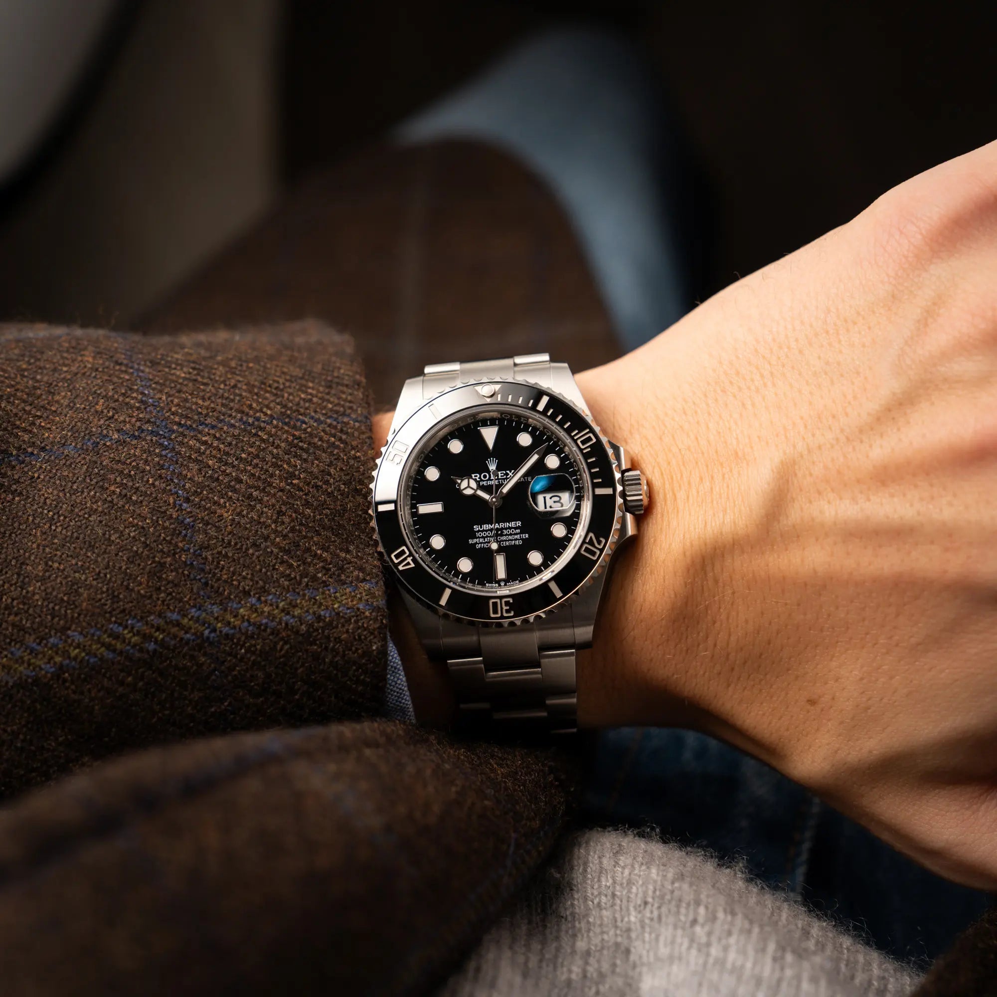 Mann trägt die Rolex Submariner Date in schwarz mit Keramik-Lünette  am Oyster-Stahlband aus 2023 mit dem 41mm-Oyster-Gehäuse für einen Wristshot an seinem Handgelenk