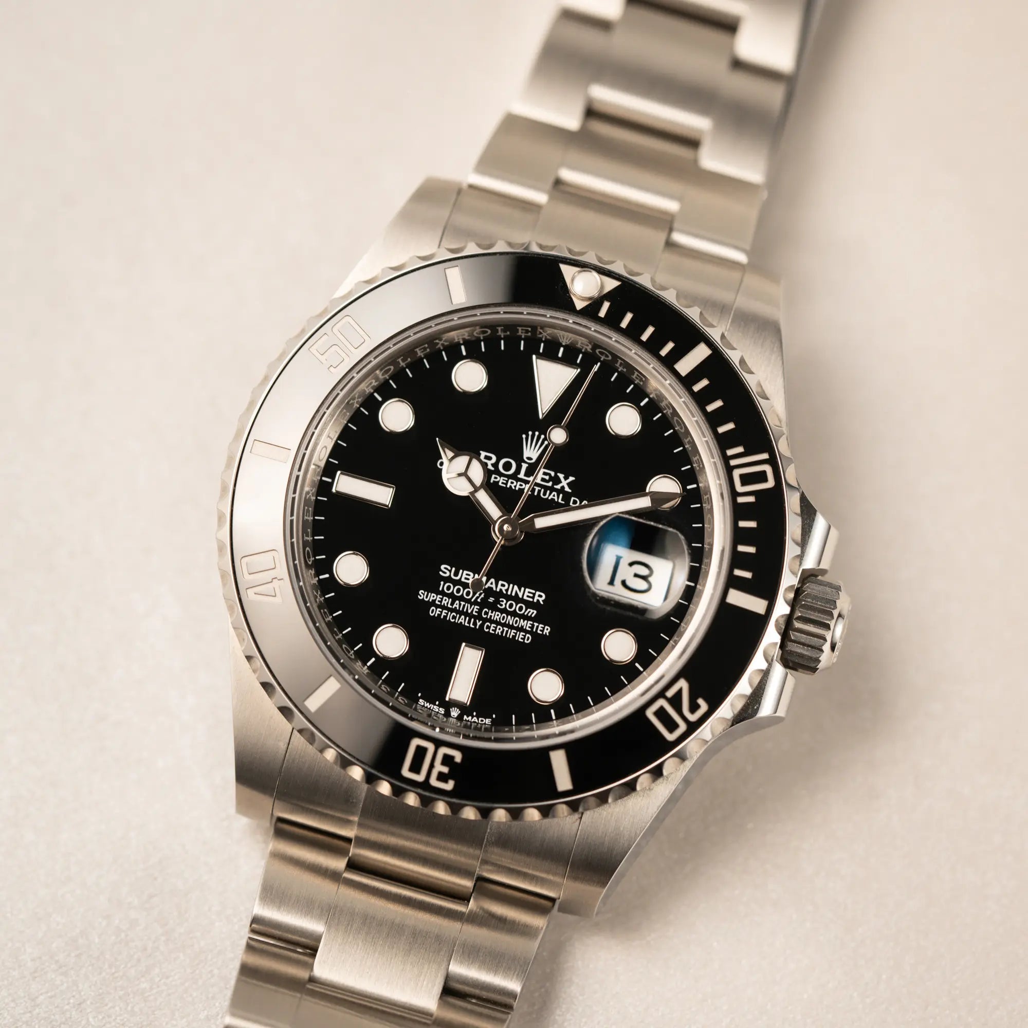 Nahaufnahme des Uhrenkopfes der Rolex Submariner Date in schwarz mit Keramik-Lünette  am Oyster-Stahlband aus 2023 mit dem 41mm-Oyster-Gehäuse