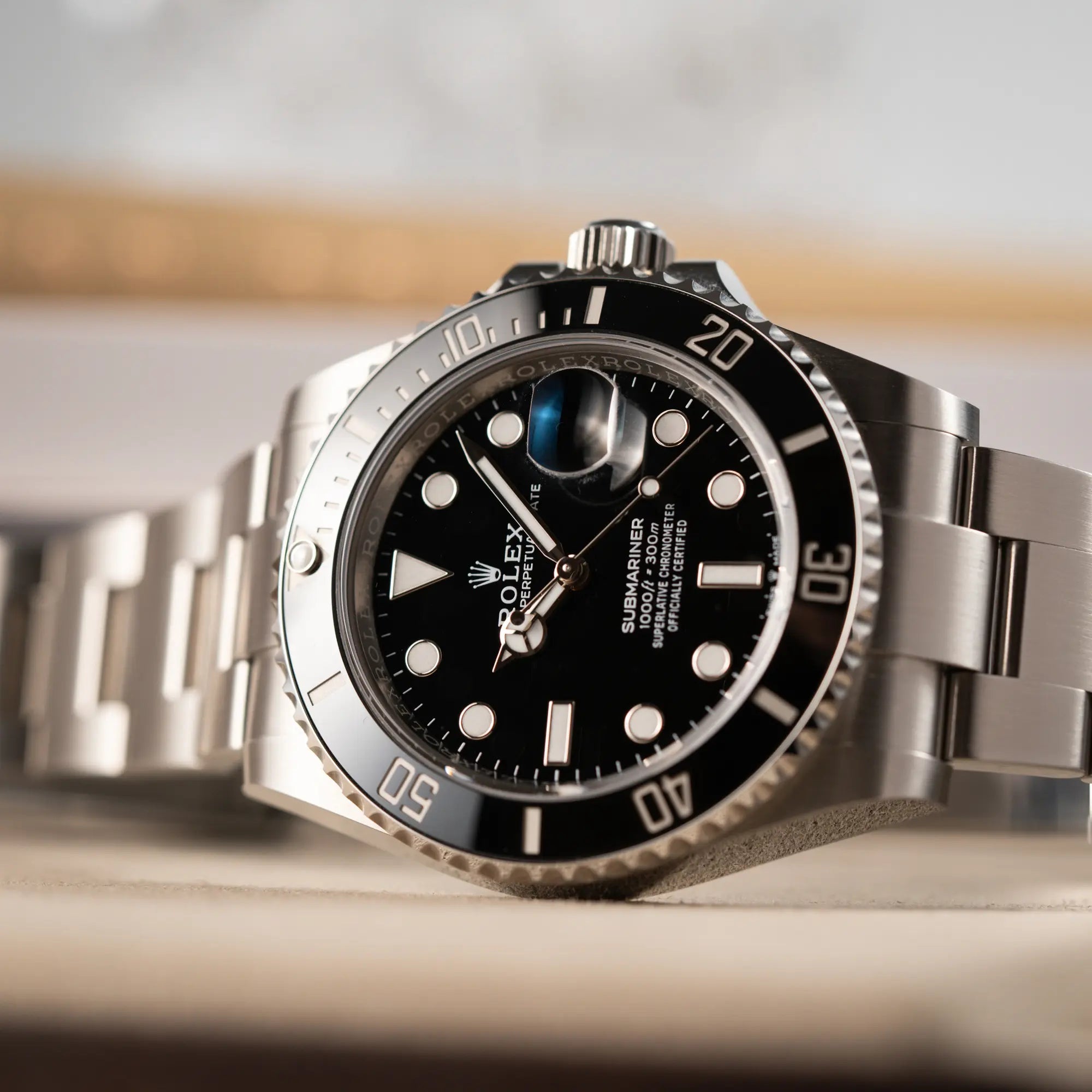 Detailaufnahme der seitlich auf dem Uhrengehäuse liegenden Rolex Submariner Date in schwarz mit Keramik-Lünette  am Oyster-Stahlband aus 2023 mit dem 41mm-Oyster-Gehäuse