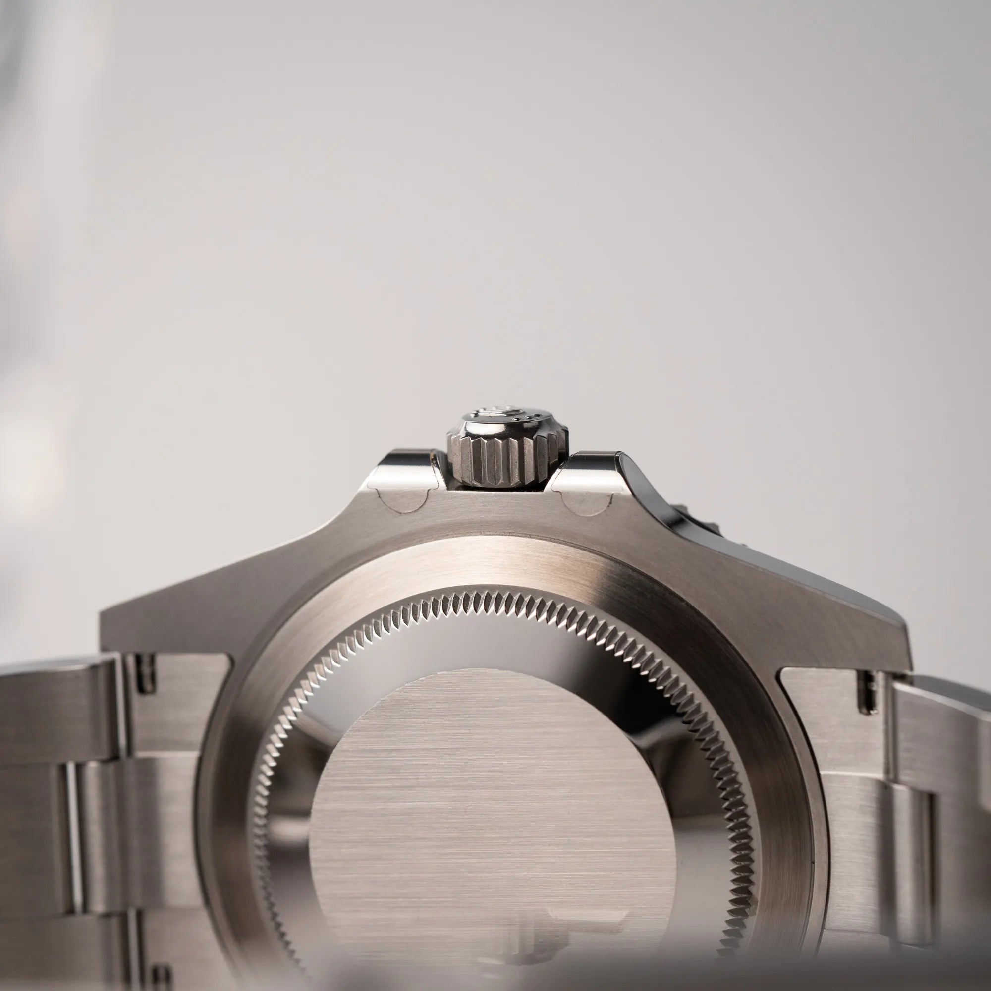 Produktfotografie zeigt die Unterseite der Rolex Submariner Date 126610LN am Oyster-Stahlband im Neuzustand aus 2024 mit Blick auf den Gehäuseboden und die noch verklebten Hörner des Kronenschutzes