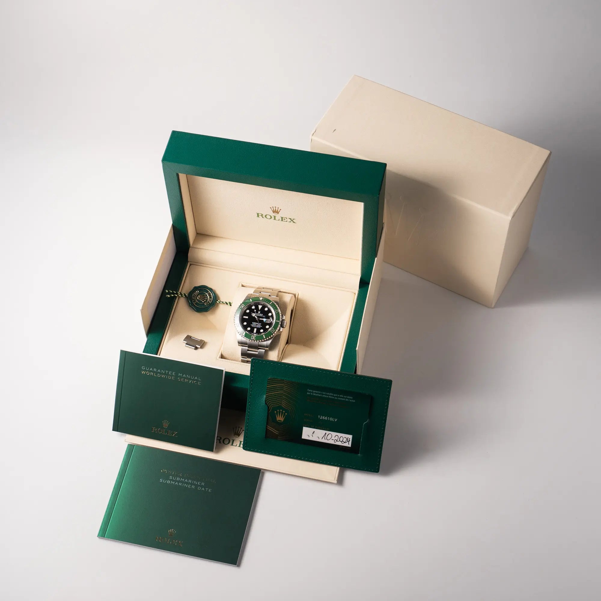 Lieferumfang zu der Rolex Submariner Date 126610LV, Nickname "Starbucks", mit schwarzem Zifferblatt und grüner Keramik-Lünette in der MK2-Ausführung am Oyster-Stahl-Band, bestehend aus Box mit Umkarton, Hangtag, Booklets und originaler Garantiekarte