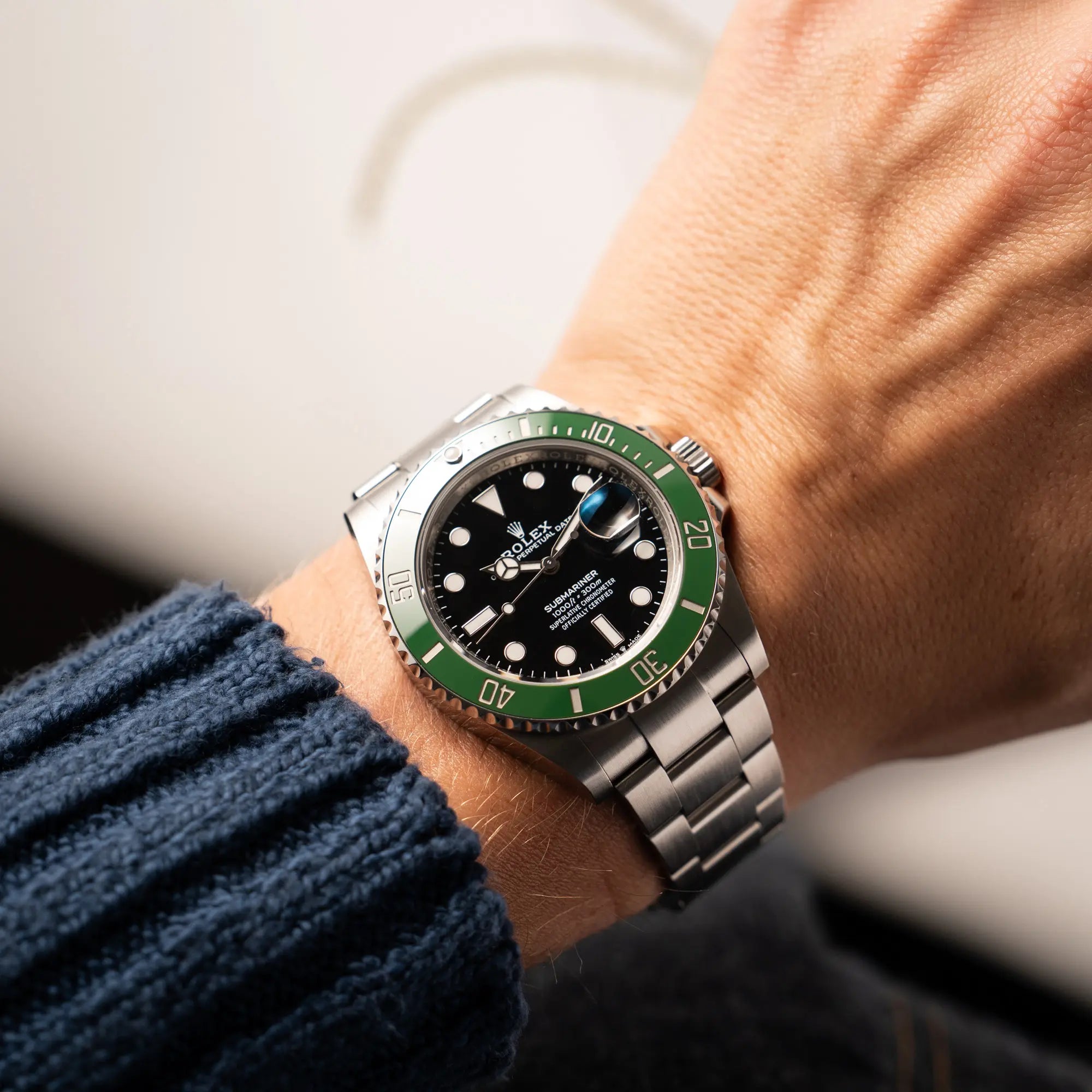 Mann trägt die Rolex Submariner Date 126610LV, Nickname "Starbucks", mit schwarzem Zifferblatt und grüner Keramik-Lünette in der MK2-Ausführung am Oyster-Stahl-Band an seinem Handgelenk