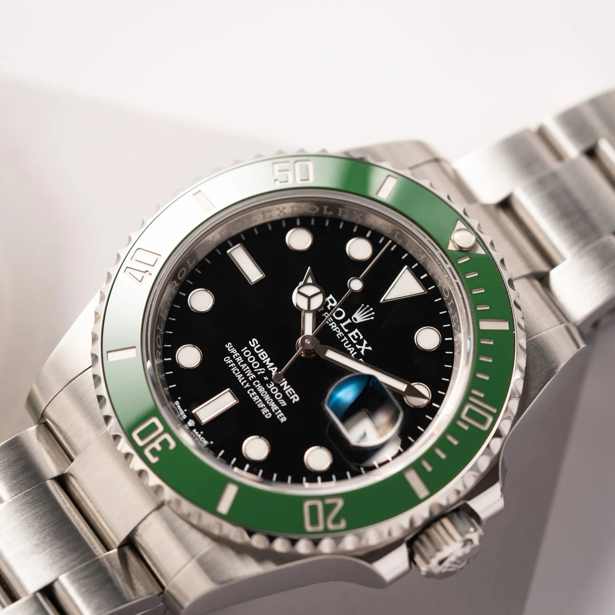Produktfotografie zeigt den Uhrenkopf der Rolex Submariner Date 126610LV, Nickname "Starbucks", mit schwarzem Zifferblatt und grüner Keramik-Lünette in der MK2-Ausführung am Oyster-Stahl-Band
