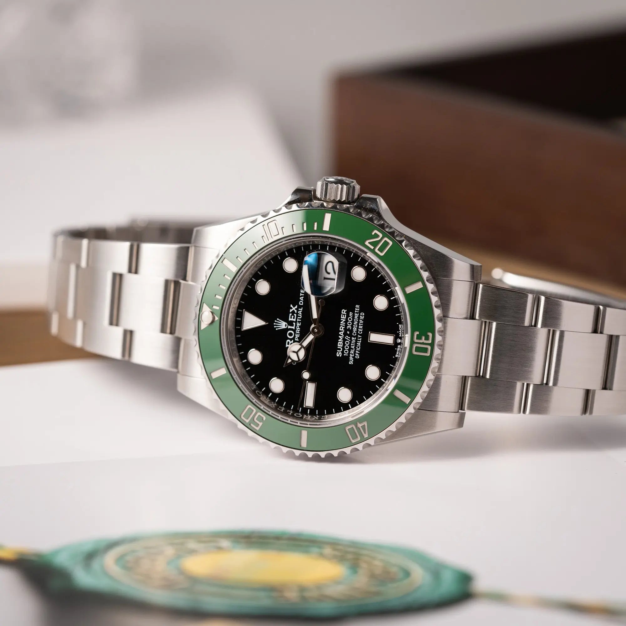 Produktfotografie der Rolex Submariner Date 126610LV, Nickname "Starbucks", mit schwarzem Zifferblatt und grüner Keramik-Lünette in der MK2-Ausführung am Oyster-Stahl-Band