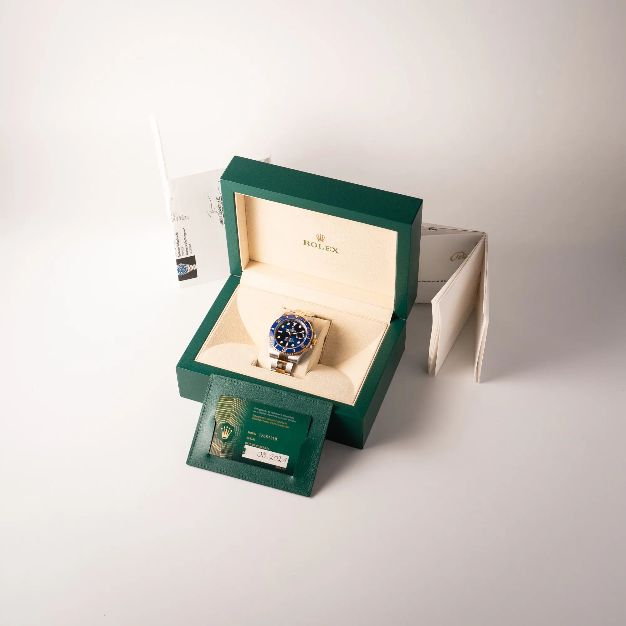 Lieferumfang zu der Rolex Submariner Date 126613LB Bluesy mit der typischen Kombination aus blauem Zifferblatt und Lünette mit dem Gehäuse und Armband aus Stahl-Gold, bestehend aus Bo, originaler Garantiekarte und Erstkaufbeleg