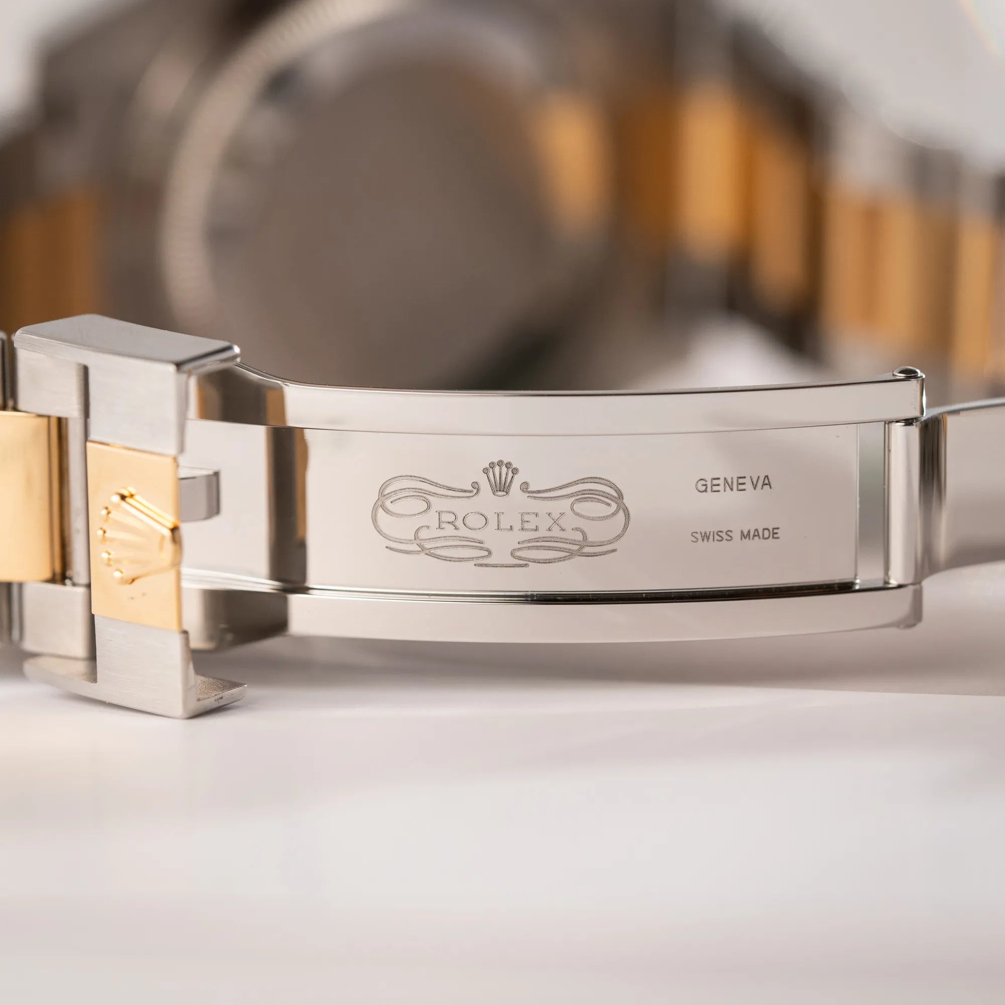 Detailaufnahme des klassischen Rolex Logos im inneren der Oyster-Faltschliesse der Rolex Submariner Date 126613LB Bluesy mit der typischen Kombination aus blauem Zifferblatt und Lünette mit dem Gehäuse und Armband aus Stahl-Gold
