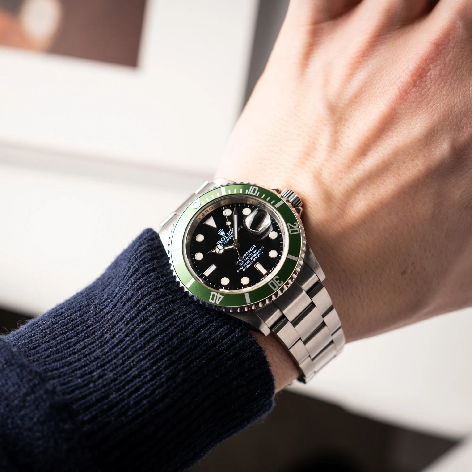 Mann trägt die Rolex Submariner Date 16610LV mit der grünen Aluminium-Lünetten-Einlage an seinem Handgelenk