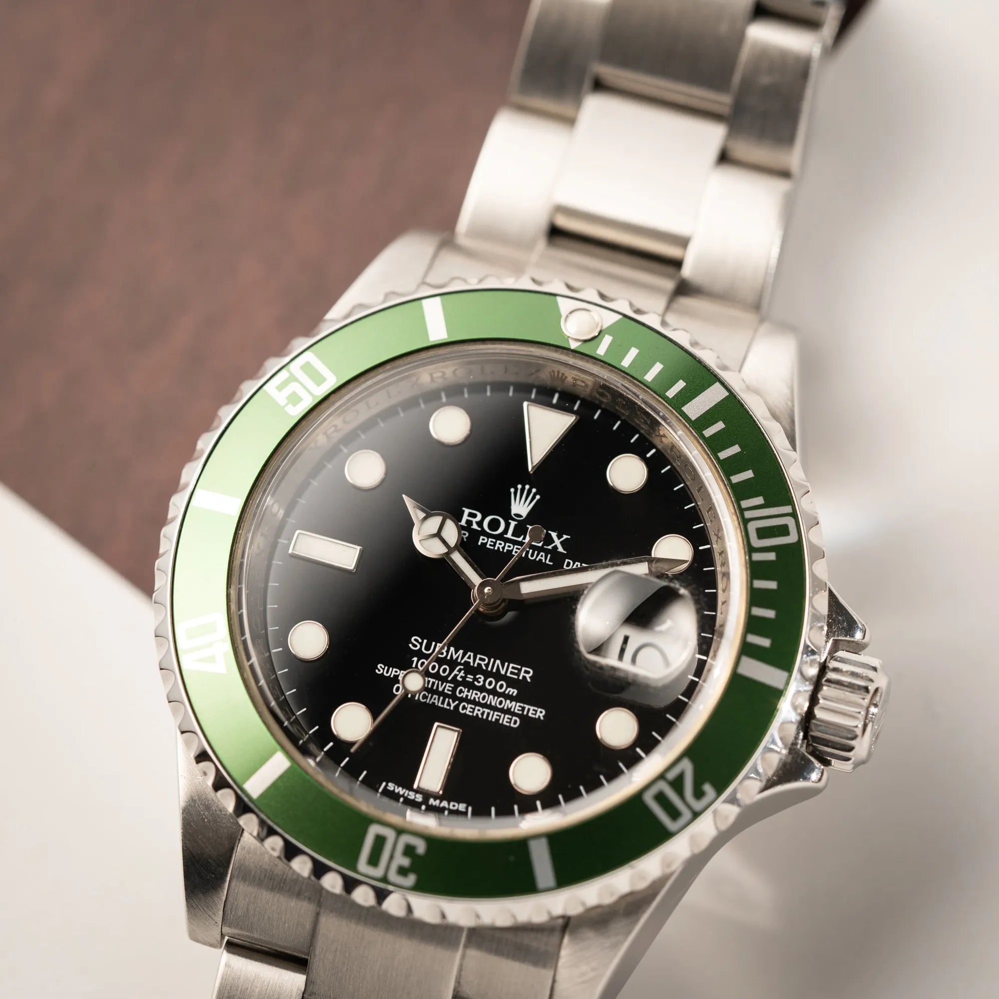 Detailaufnahme des Uhrenkopfes von der Rolex Submariner Date 16610LV mit der grünen Aluminium-Lünetten-Einlage