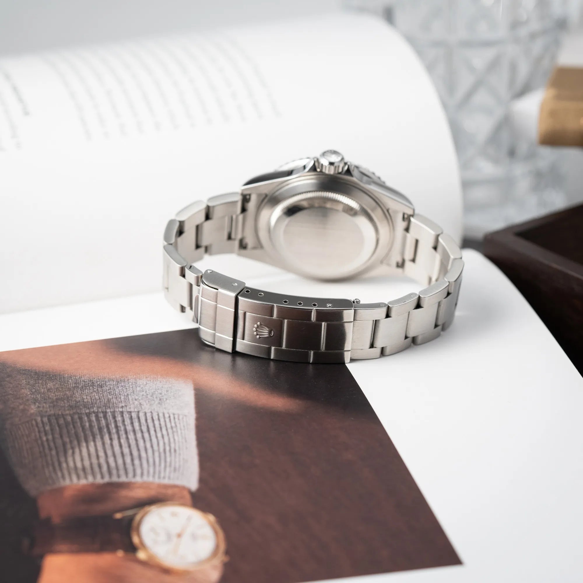 Produktfotografie der Rolex Submariner Date 16610LV mit der grünen Aluminium-Lünetten-Einlage zeigt das Oyster-Stahlband und die Schliesse in einem sehr guten Zustand