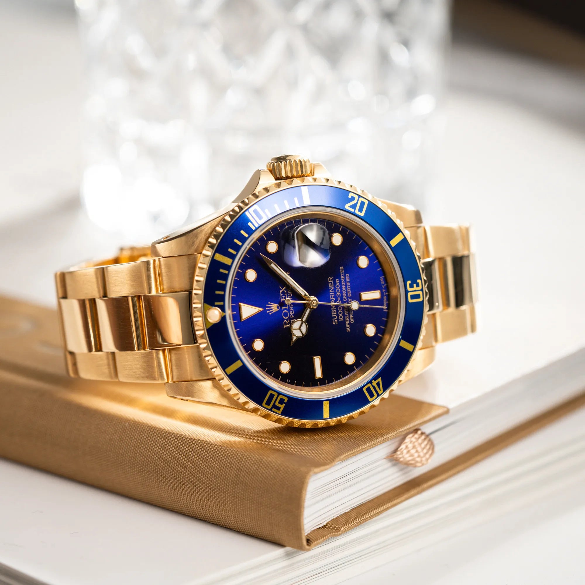 Produktfotografie der Rolex Submariner Date 16618 aus 18Karat Gelbgold mit blauer Lünetten-Einlage und einem sich von BLAU zu LILA verfärbtem Purple-Zifferblatt