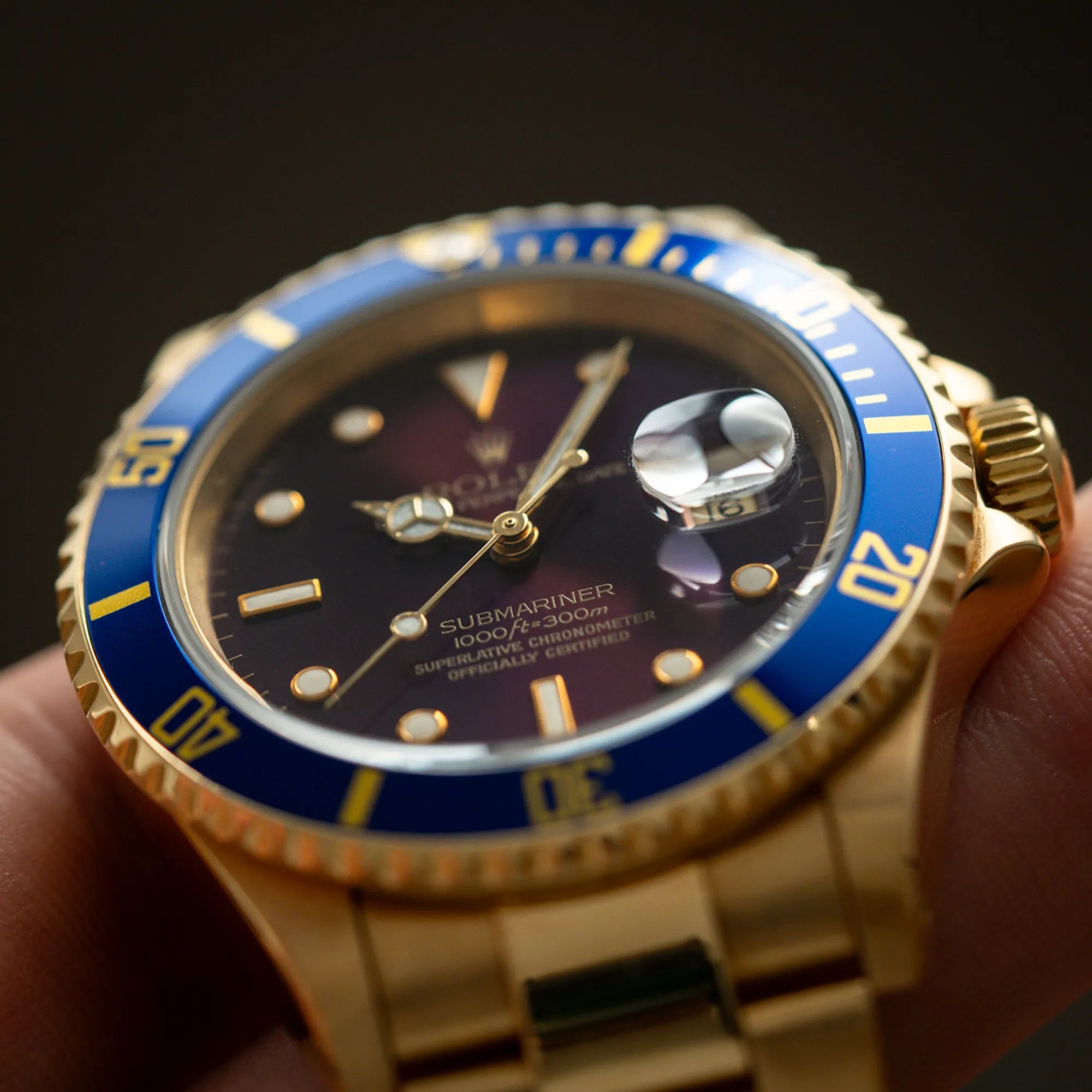 Produktfotografie der Rolex Submariner Date 16618 aus 18Karat Gelbgold mit blauer Lünetten-Einlage und einem sich von BLAU zu LILA verfärbtem Purple-Zifferblatt