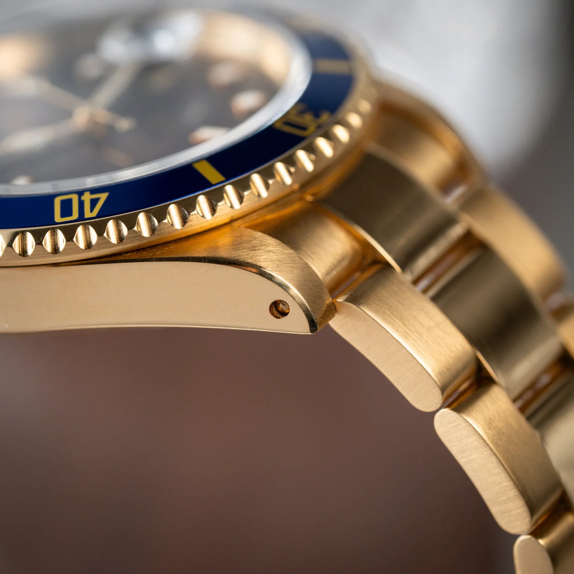 Produktfotografie der Rolex Submariner Date 16618 aus 18Karat Gelbgold mit blauer Lünetten-Einlage und einem sich von BLAU zu LILA verfärbtem Purple-Zifferblatt