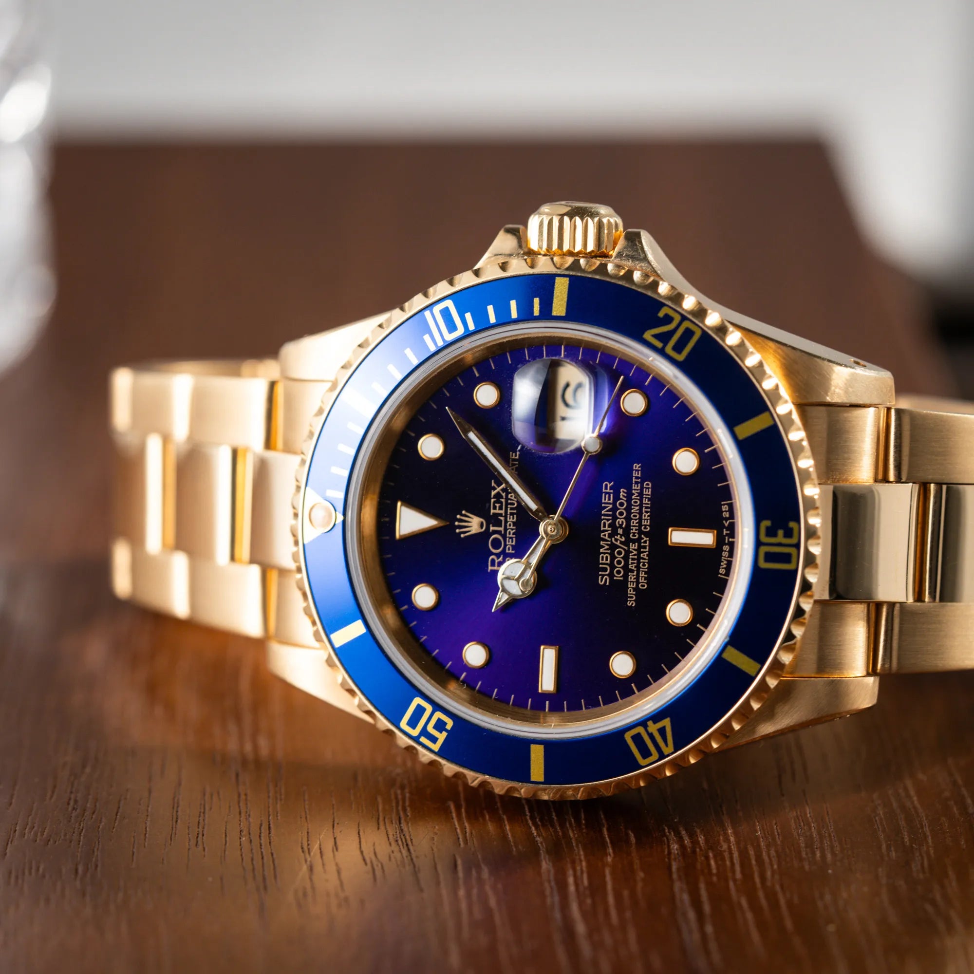 Produktfotografie der Rolex Submariner Date 16618 aus 18Karat Gelbgold mit blauer Lünetten-Einlage und einem sich von BLAU zu LILA verfärbtem Purple-Zifferblatt