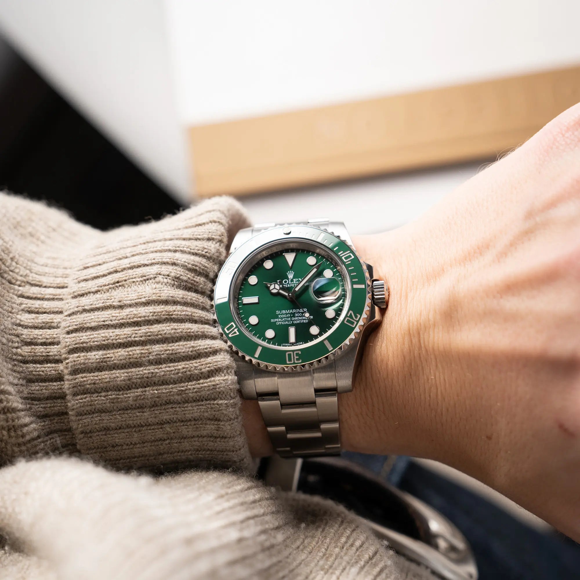 Mann trägt die Rolex Submariner Date 116610LV mit dem Nickname "Hulk" mit grünem Zifferblatt und grüner Lünette in einem sehr guten Zustand an seiner Hand
