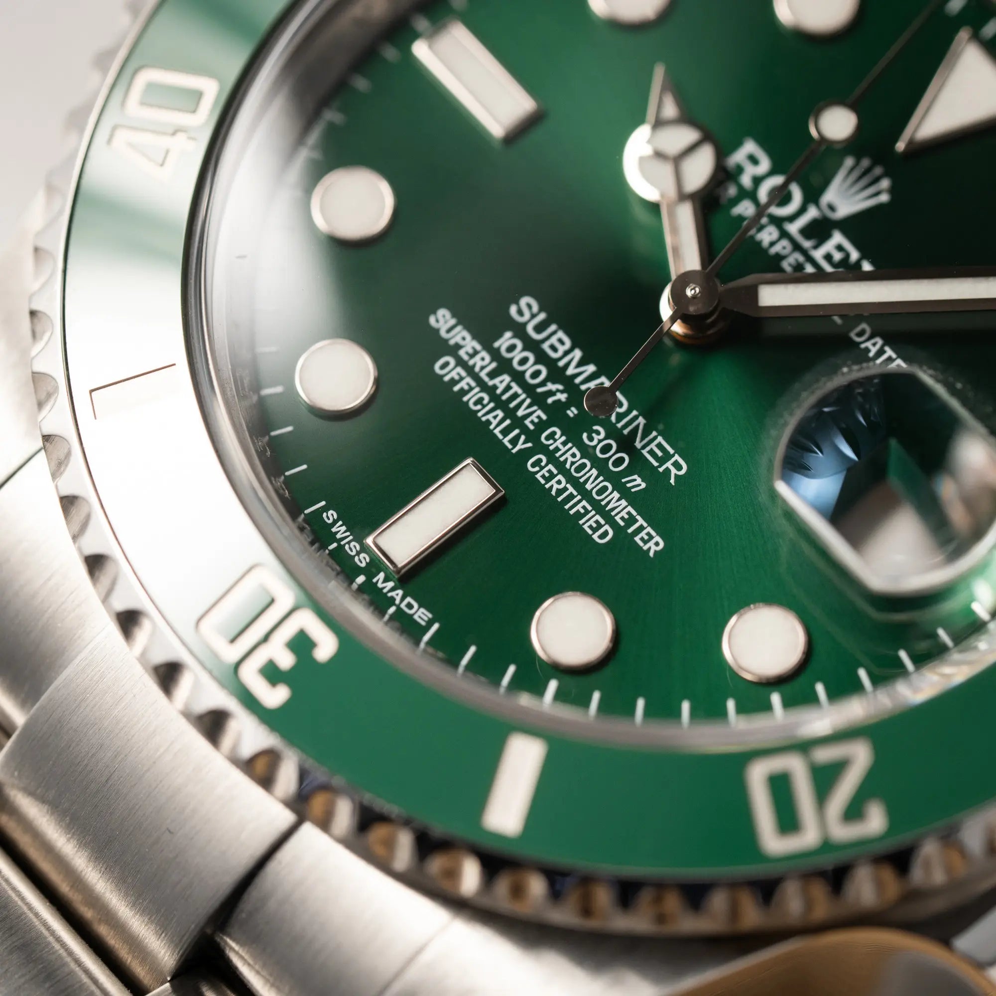 Detailaufnahme des Index bei 6 Uhr von der Rolex Submariner Date 116610LV mit dem Nickname "Hulk" mit grünem Zifferblatt und grüner Lünette in einem sehr guten Zustand
