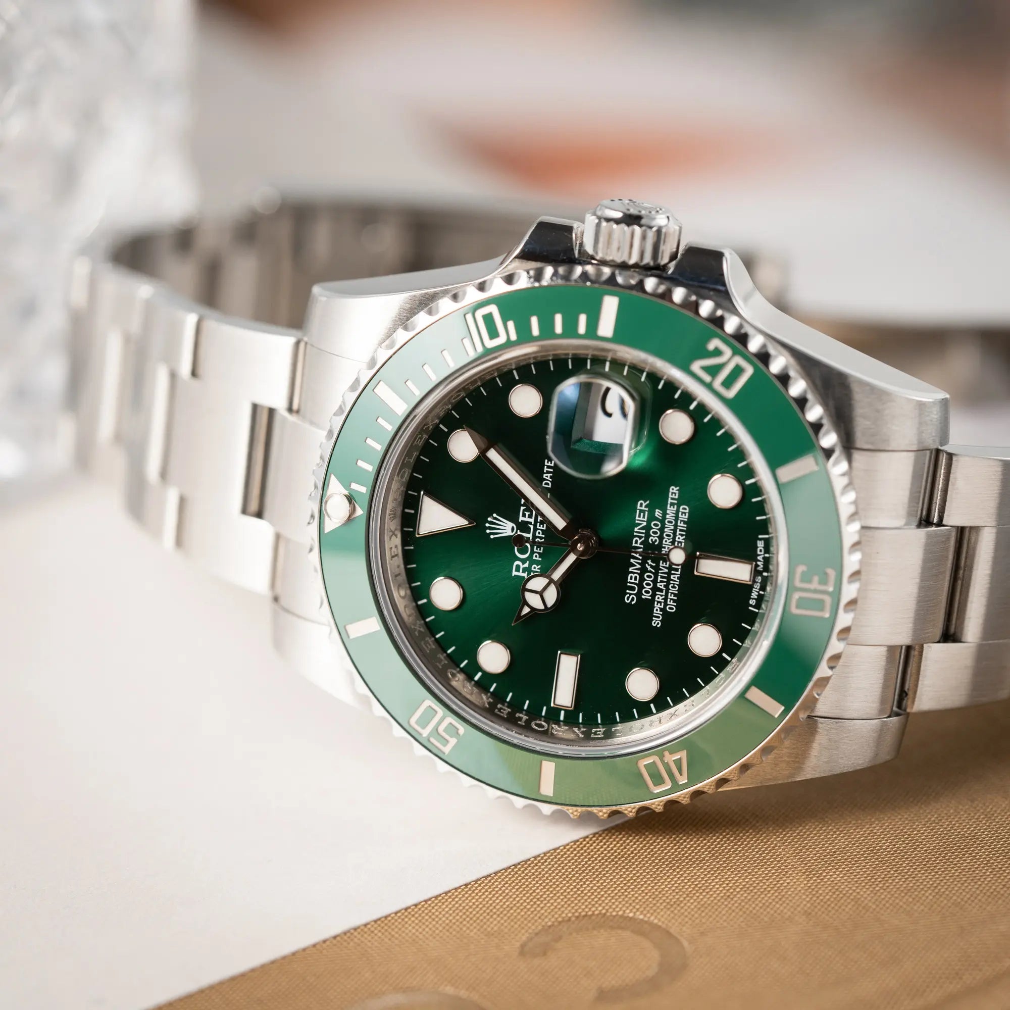 Produktfotografie der Rolex Submariner Date 116610LV mit dem Nickname "Hulk" mit grünem Zifferblatt und grüner Lünette in einem sehr guten Zustand zeigt den Sonnenschliff des Zifferblatt mit seinen verschiedenen Grüntönen