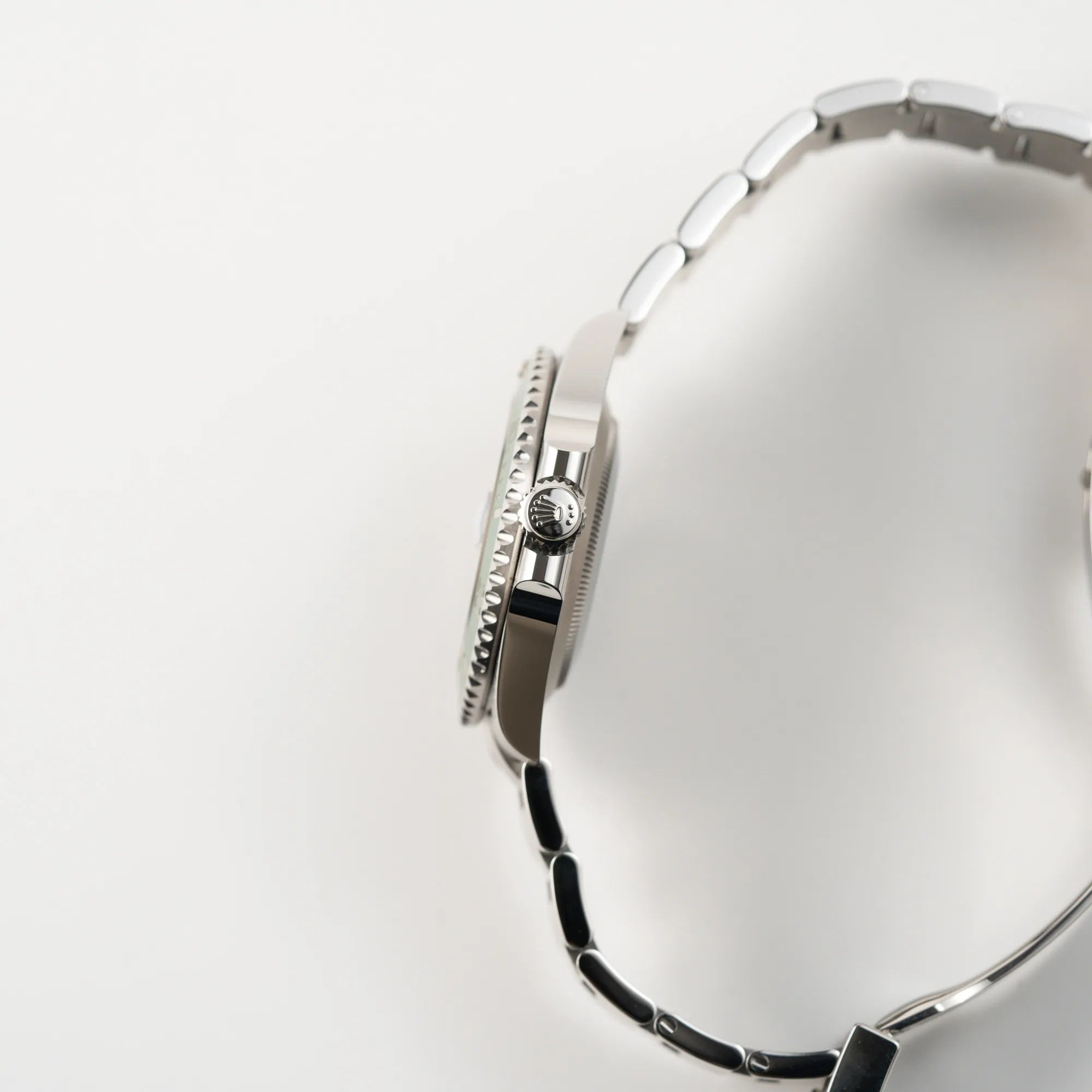 Seitliche Gehäuseflanke mit Aufzugskrone und Kronenschutz der Rolex Submariner Date Starbucks 126610LV Mark 2 aus 2025 mit der typischen grünen Cerachrom-Lünette