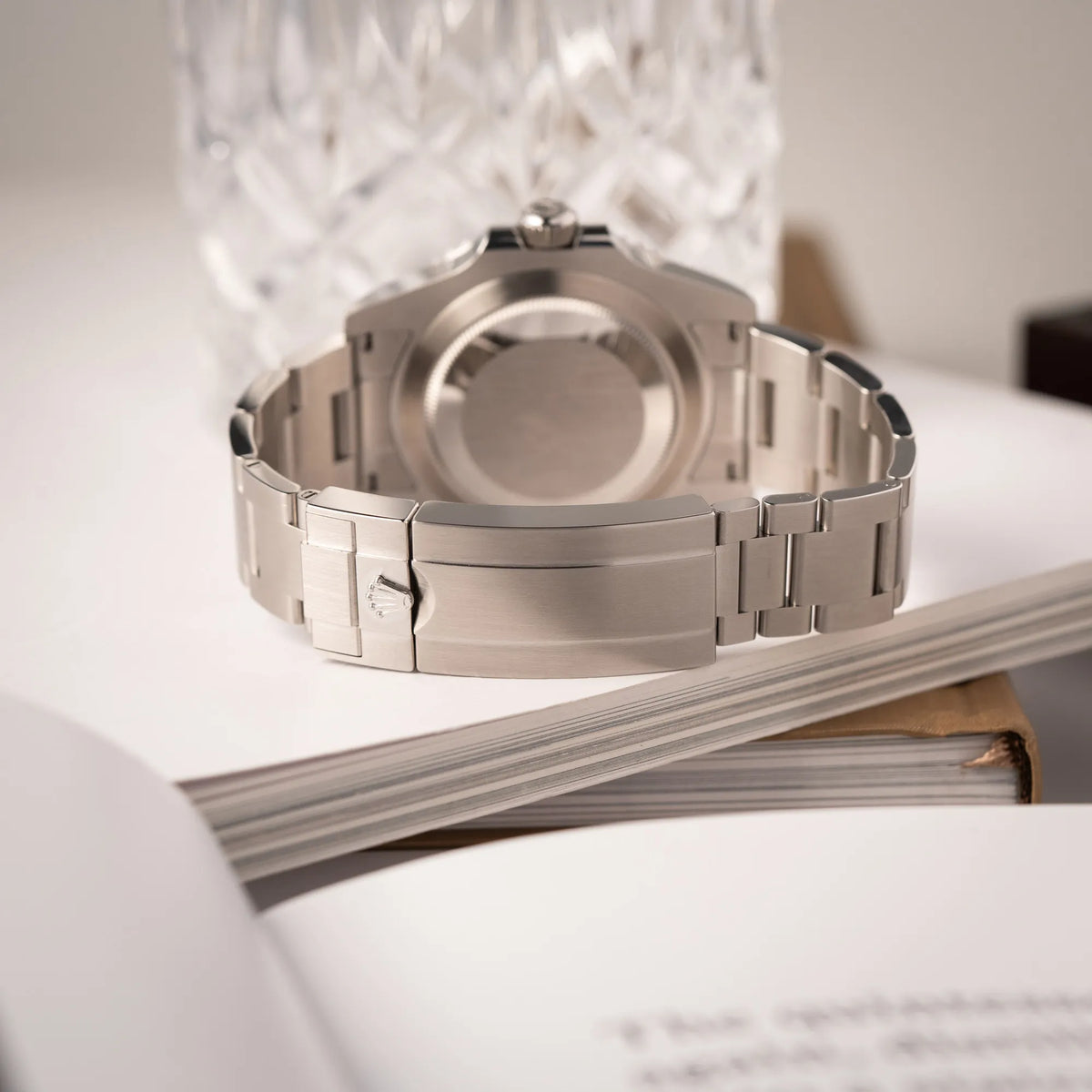 Produktfotografie der Rolex Submariner No Date der Referenz 124060 mit schwarzem Zifferblatt und schwarzer Keramik-Lünette an einem Oytser-Stahlband im Neuzustand zeigt die Oyster-Schliesse