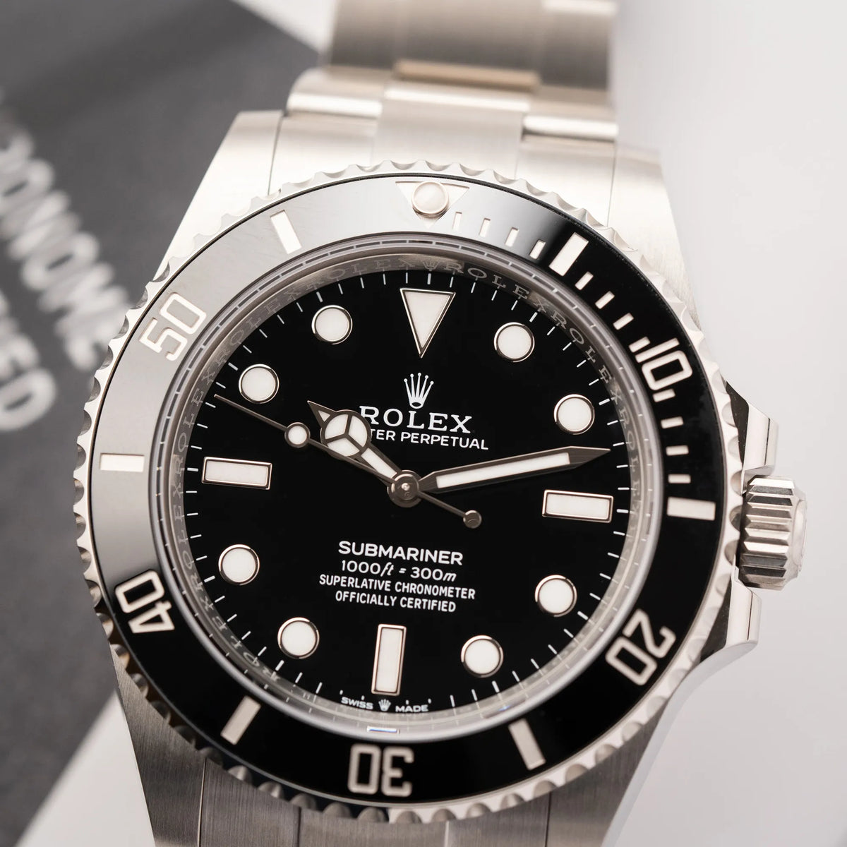 Detailaufnahme des Uhrenkopfes der Rolex Submariner No Date der Referenz 124060 mit schwarzem Zifferblatt und schwarzer Keramik-Lünette an einem Oytser-Stahlband im Neuzustand
