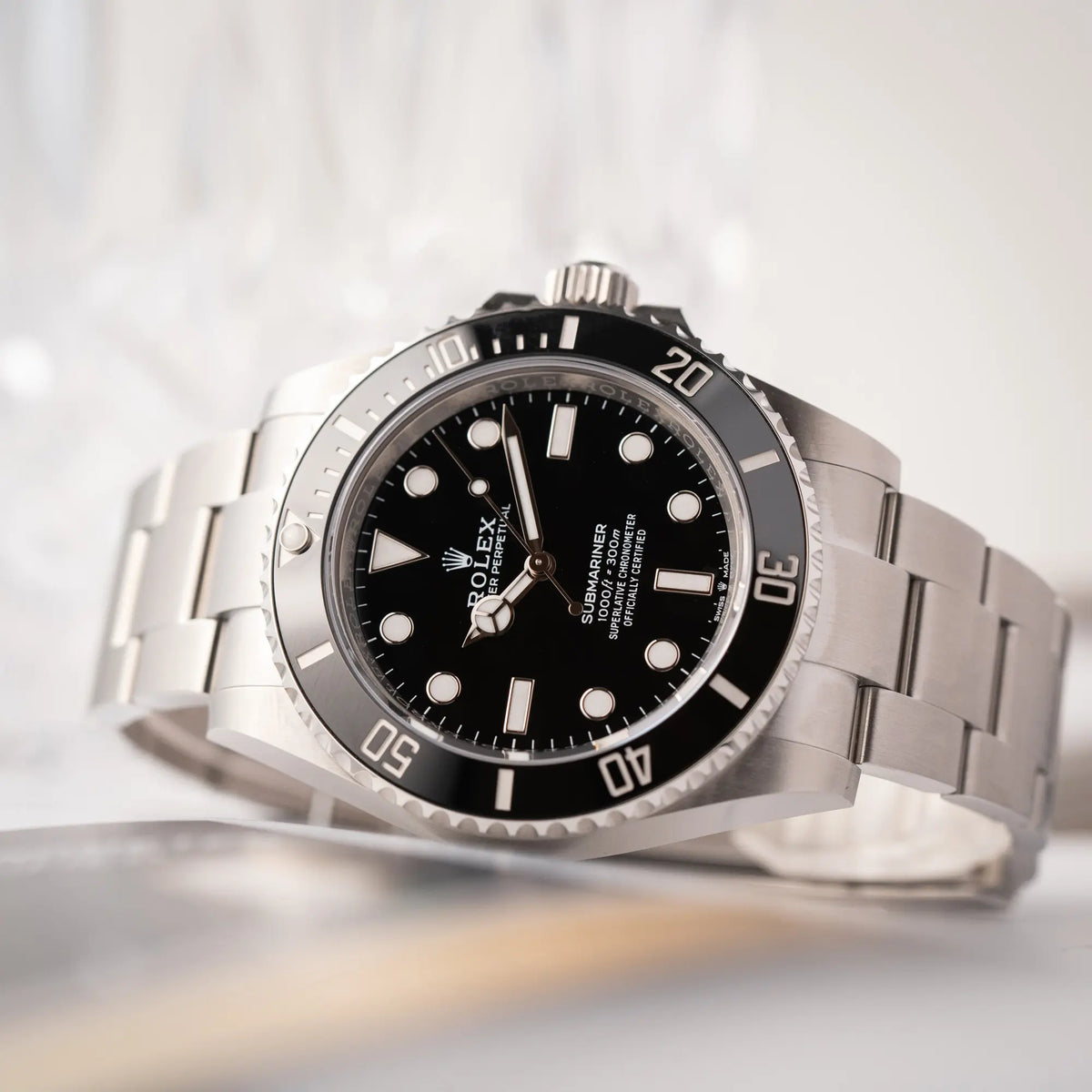 Detailreiche Produktfotografie der Rolex Submariner No Date der Referenz 124060 mit schwarzem Zifferblatt und schwarzer Keramik-Lünette an einem Oytser-Stahlband im Neuzustand